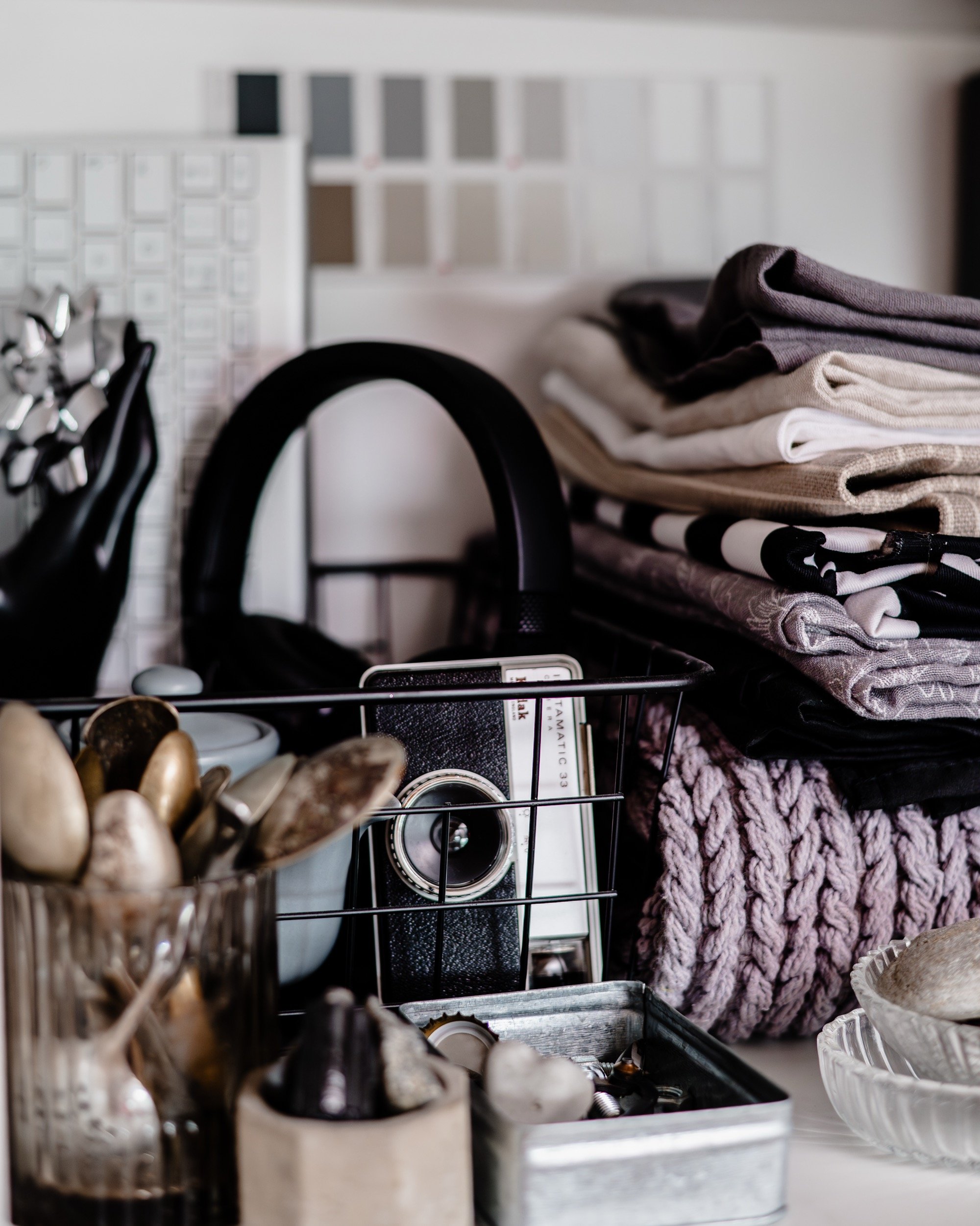 monochrome props including a vintage camera, headphones and linens