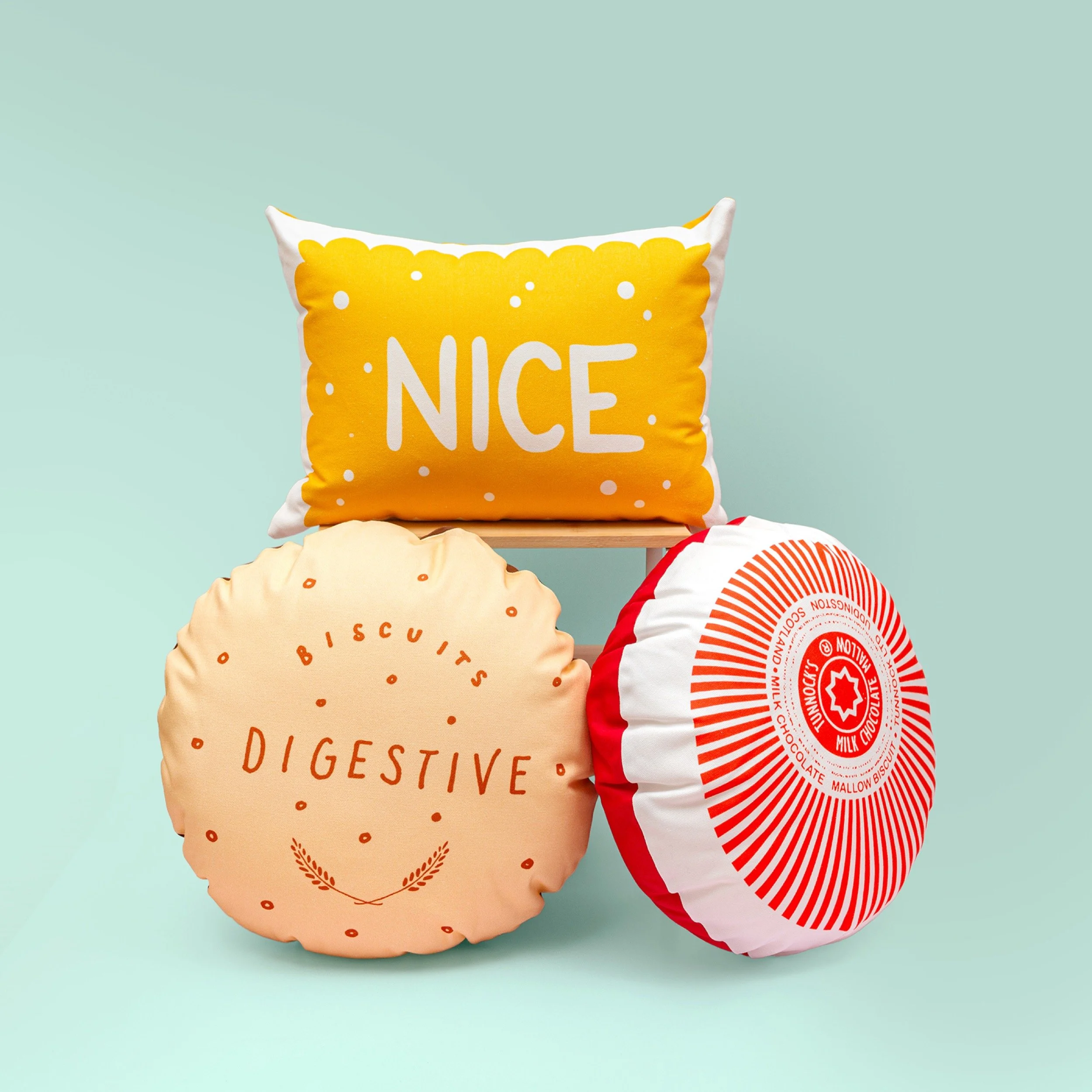 Three biscuit cushions are photographed on a mint green background.