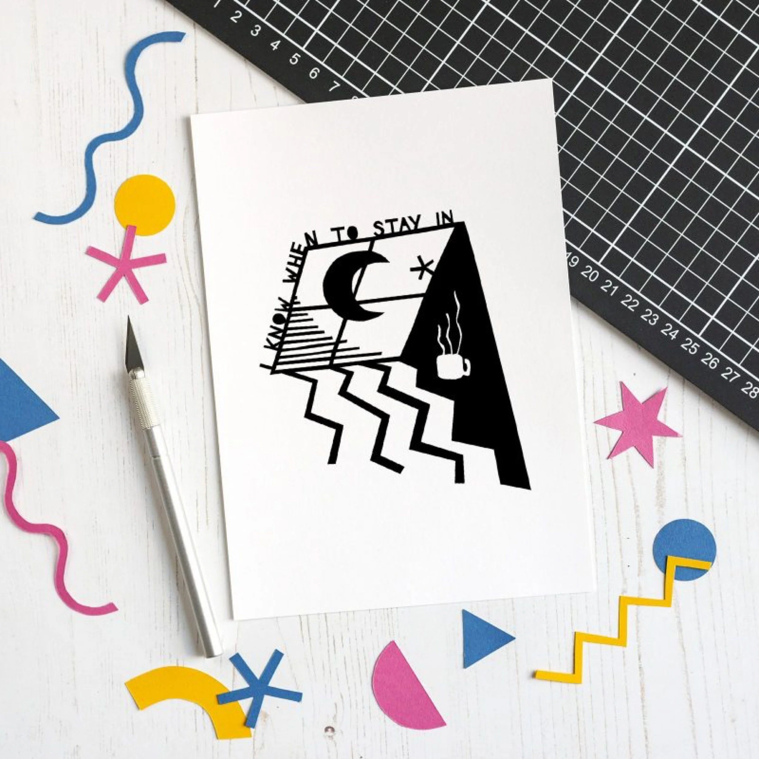 A black and white abstract illustration on a piece of paper, with the words "when to stay in" and a stylized scene including a window, a crescent moon, a star, a steaming cup, and geometric patterns. 