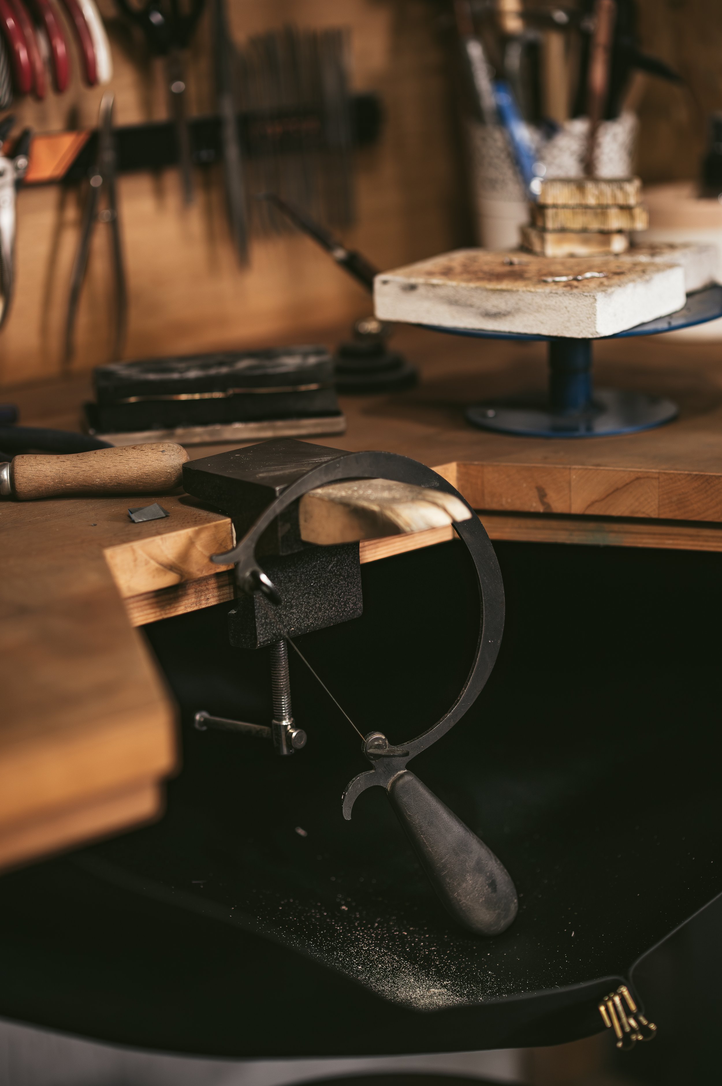 A woodworking workshop with tools including a saw, hammer, and chisels on a wooden workbench.