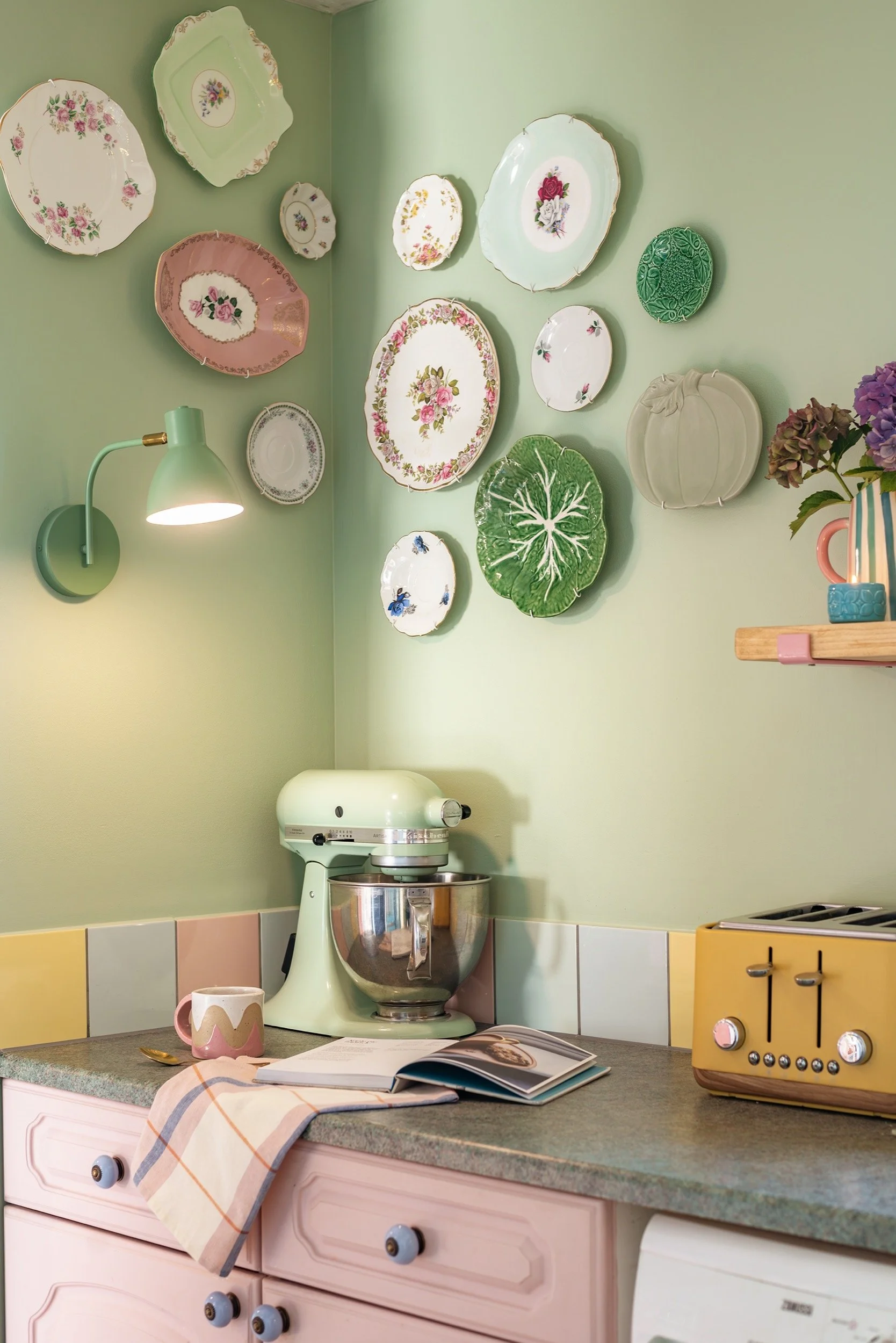 vintage plates are hung on a kitchen wall next to a stand mixer
