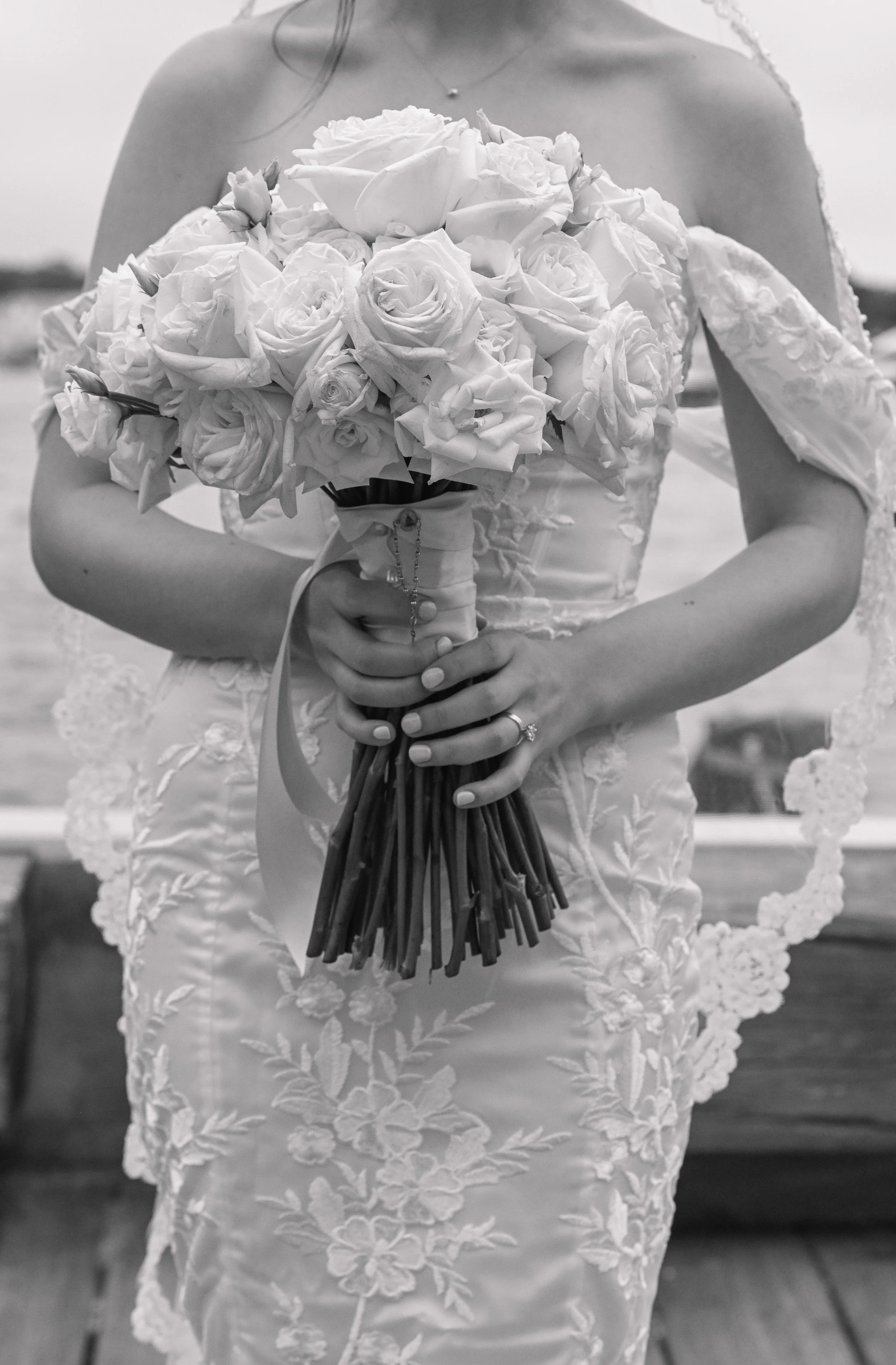 A woman in a wedding dress holding a bouquet of roses and other flowers.