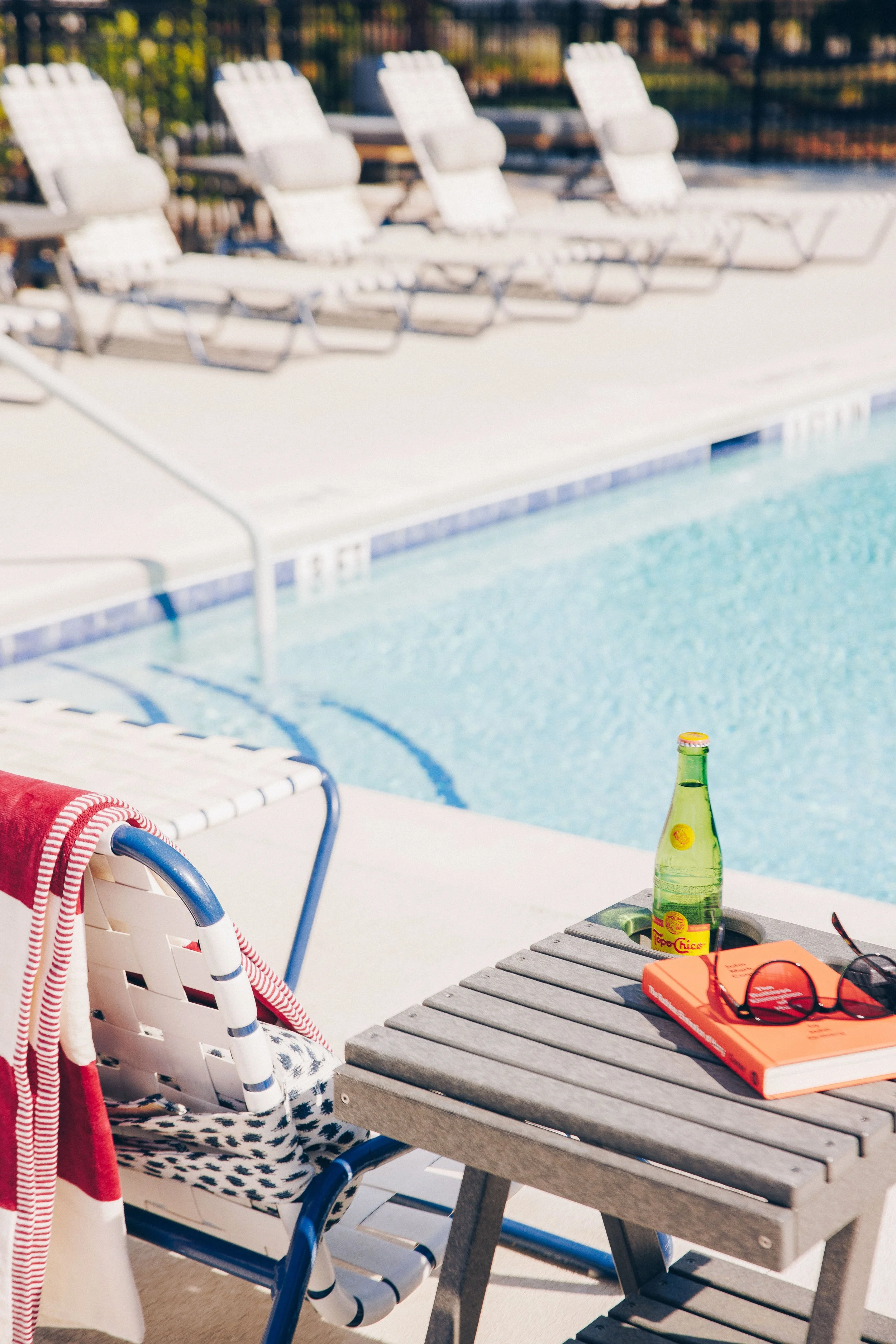 Resident enjoying the resort-style swimming pool at The Grove at Ardsley Park luxury apartments in Savannah, GA