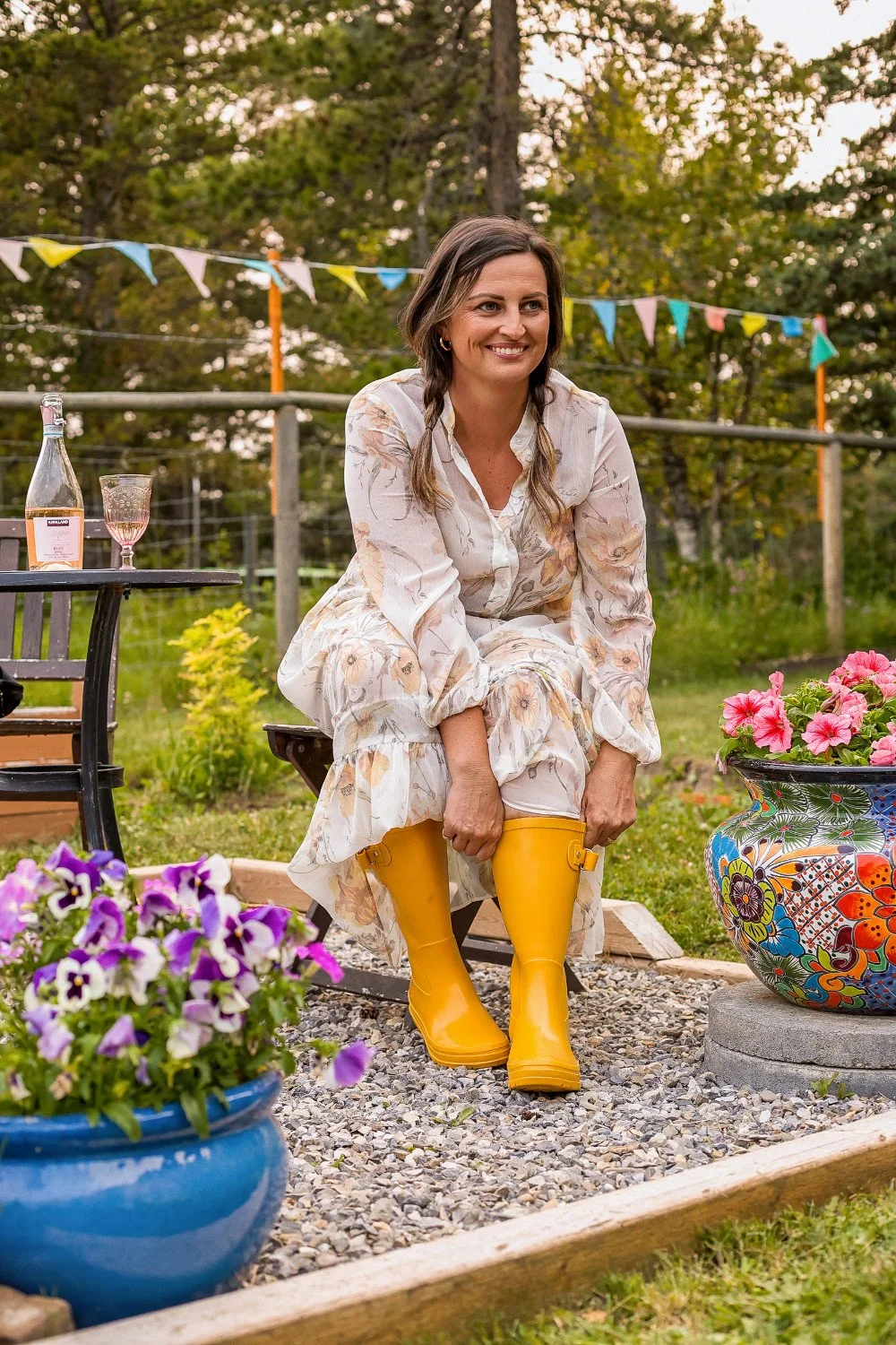 woman putting on her rubber boots to get to work in flower farm prosecco in background