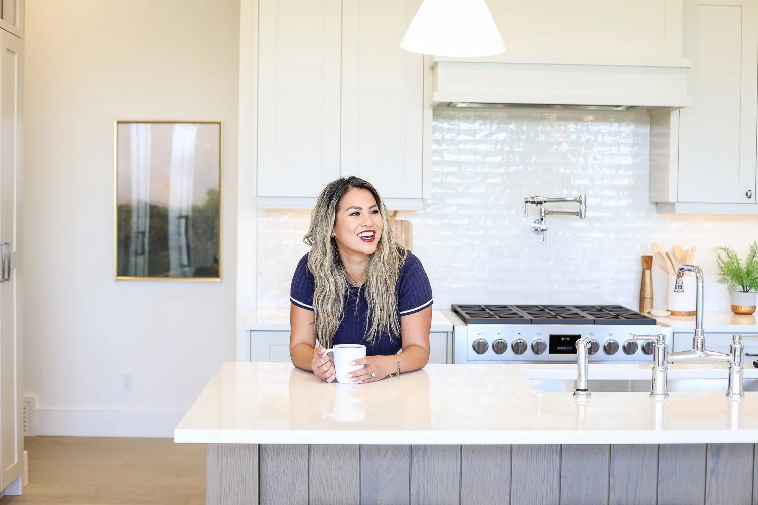 woman leaning on counter and laughing during her brand photoshoot for women entrepreneurs