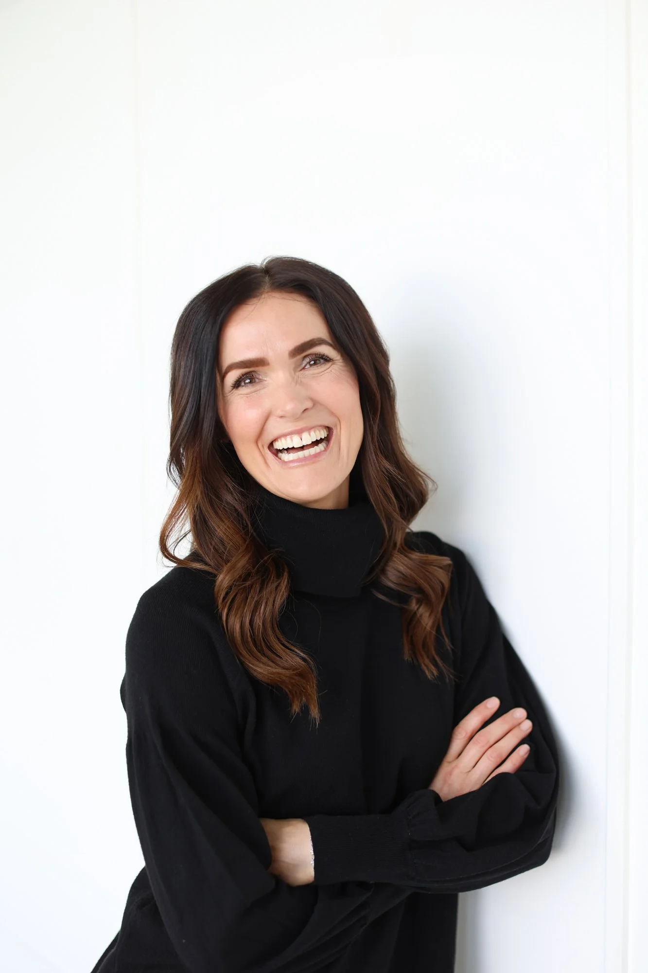 woman smiling in a black turleneck sweater
