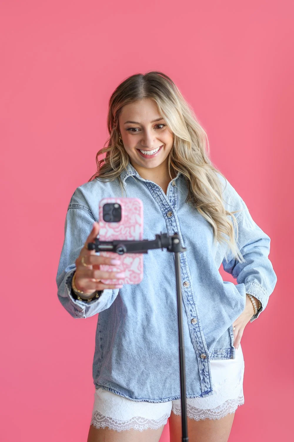 woman looking at phone and smiling on a tripod