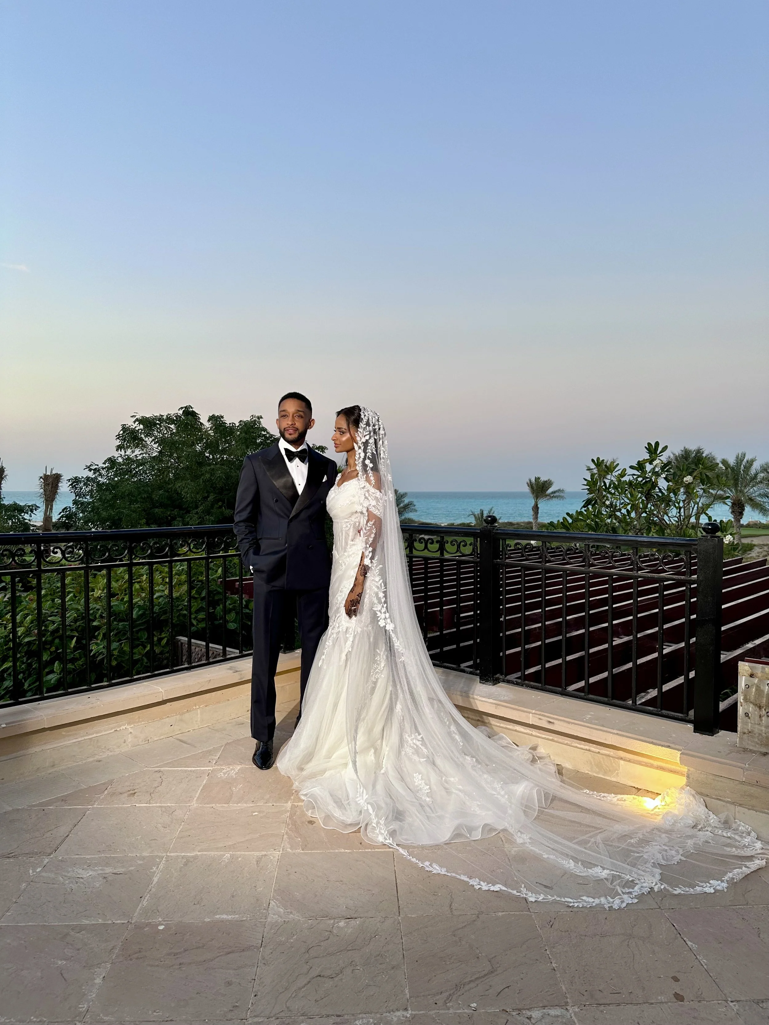 A bride and groom standing with a view of the ocean in abu dhabi. wedding content creation dubai. wedding content creator. wedding photography.