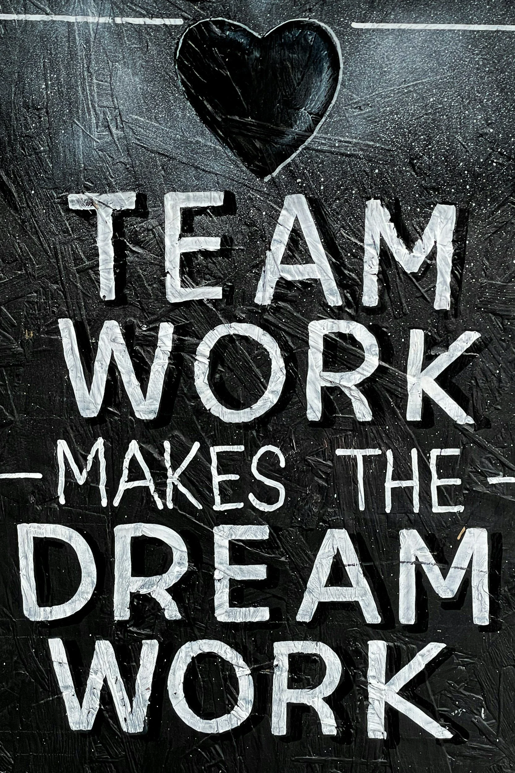 white writing on black background "team work makes the dream work"