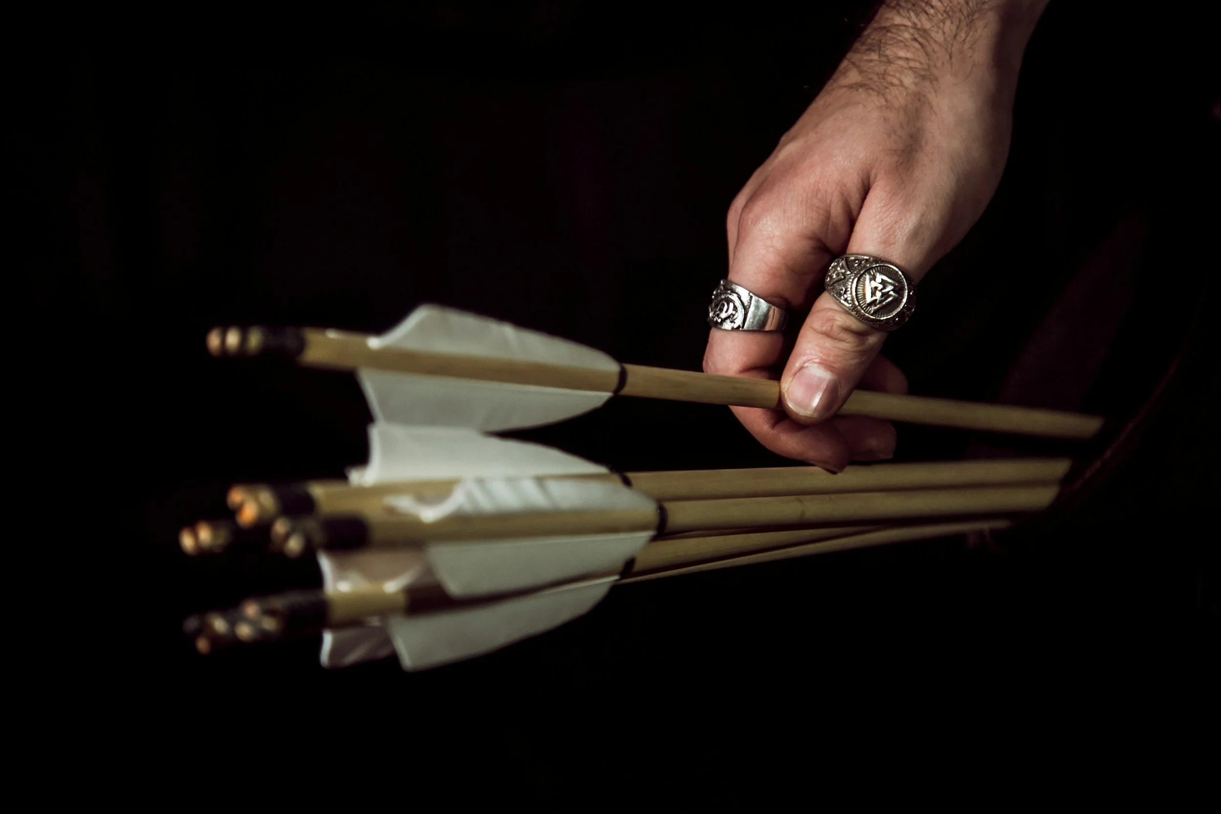 quiver of arrows and hand pulling an arrow out of it