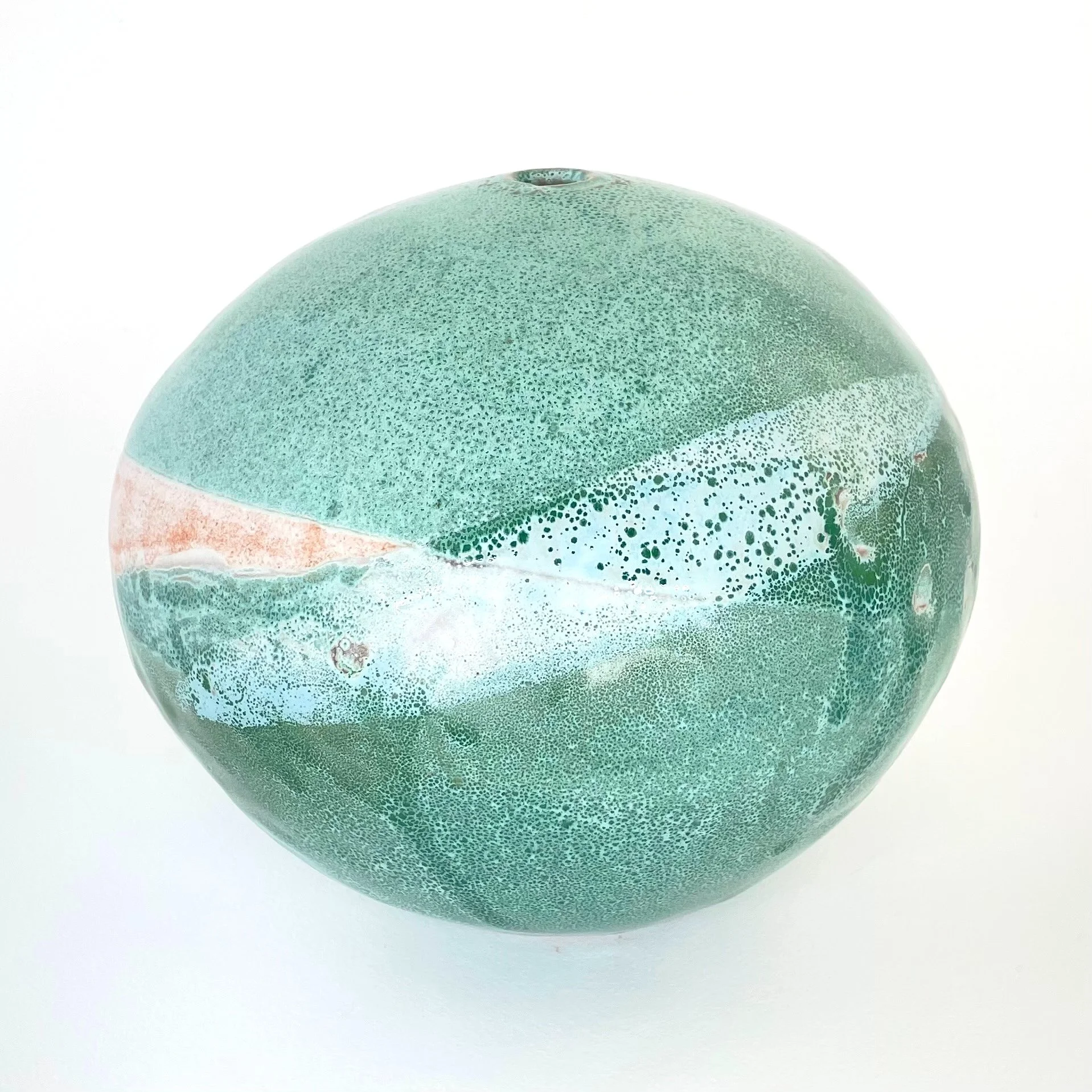 Green ceramic sphere with a textured, speckled pattern and a white streak along the middle against a plain white background.