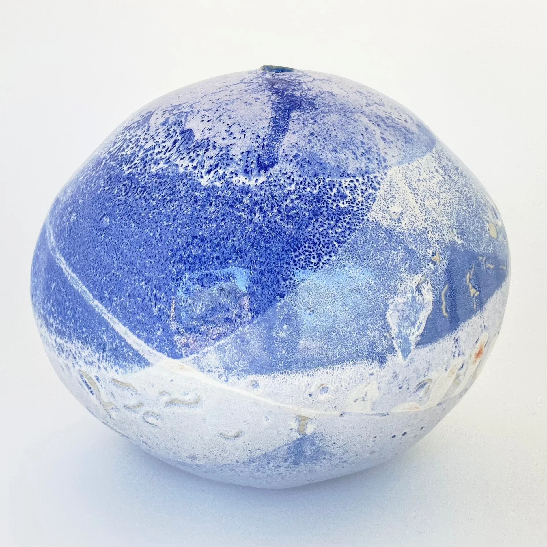 Blue and white marbled ceramic orb with a spherical shape and textured surface.
