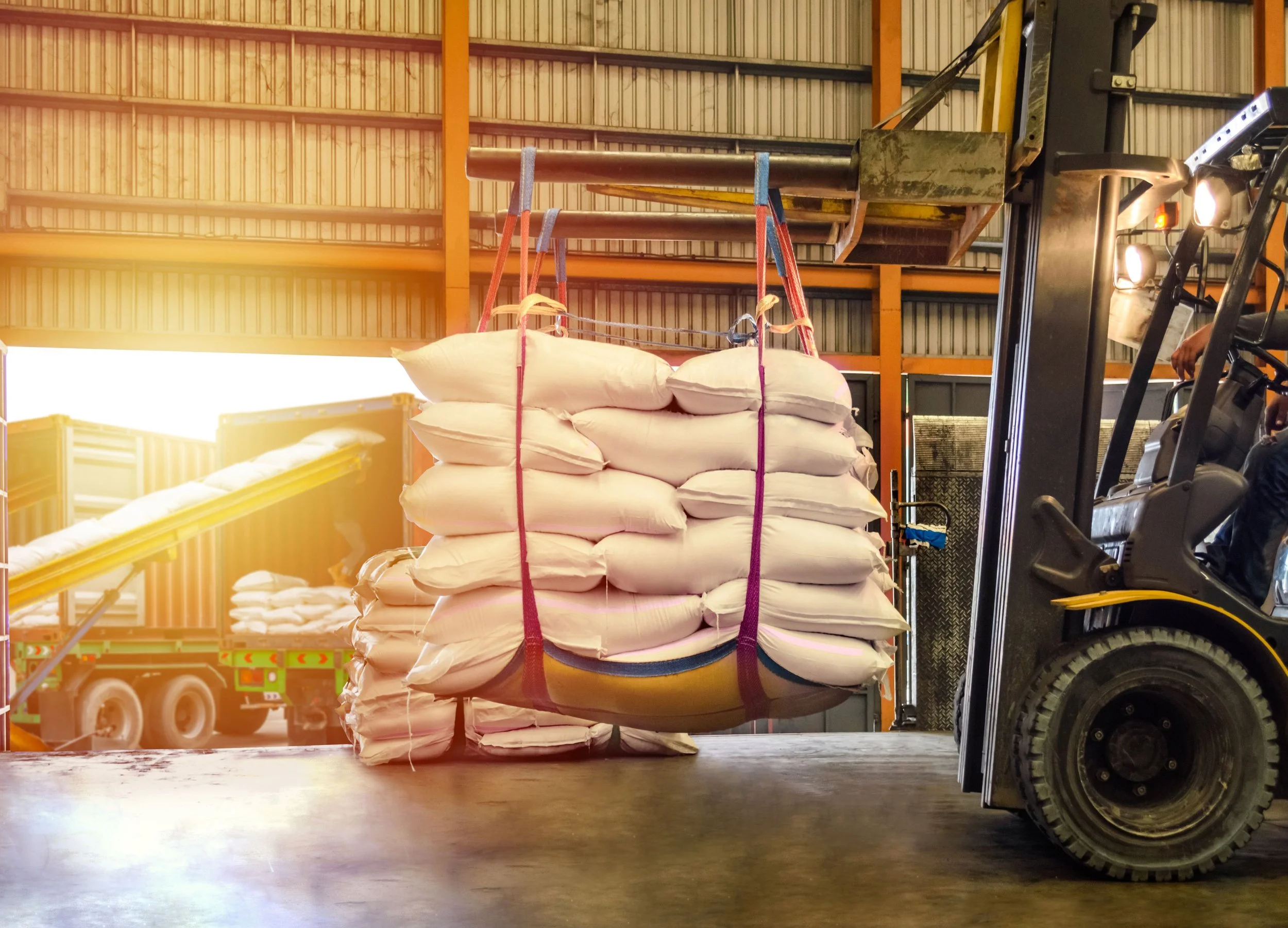 Gabelstapler hebt mehrere Säcke in einem Lagerraum.