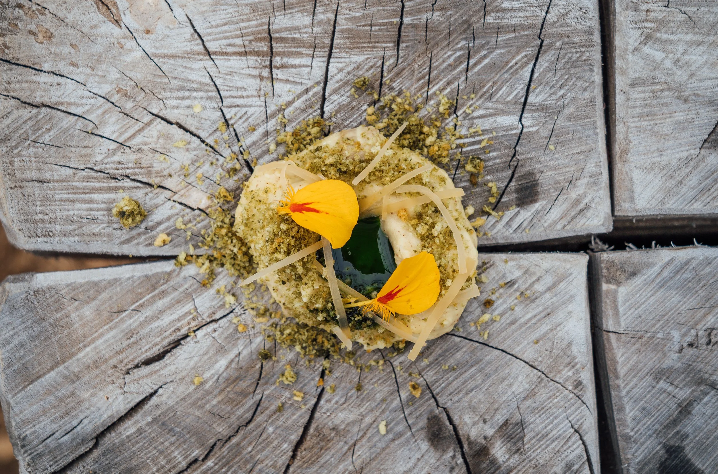 A small dish with garnishes placed on a weathered wooden surface.