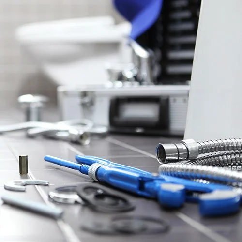 Tools and plumbing fixtures on the floor.