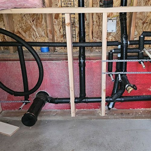 Exposed pipes and drains during a remodeling project.