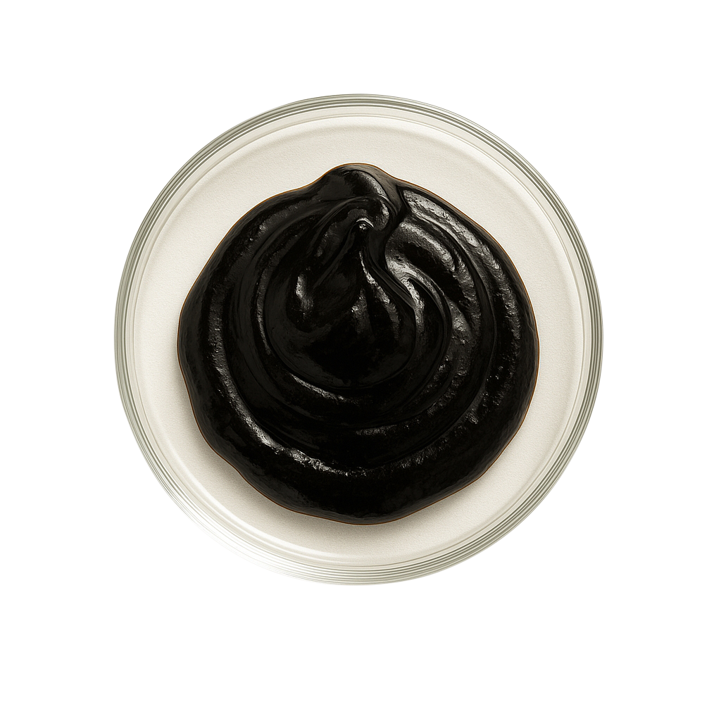 Pile of black seaweed flakes with a piece of black seaweed on a white background.
