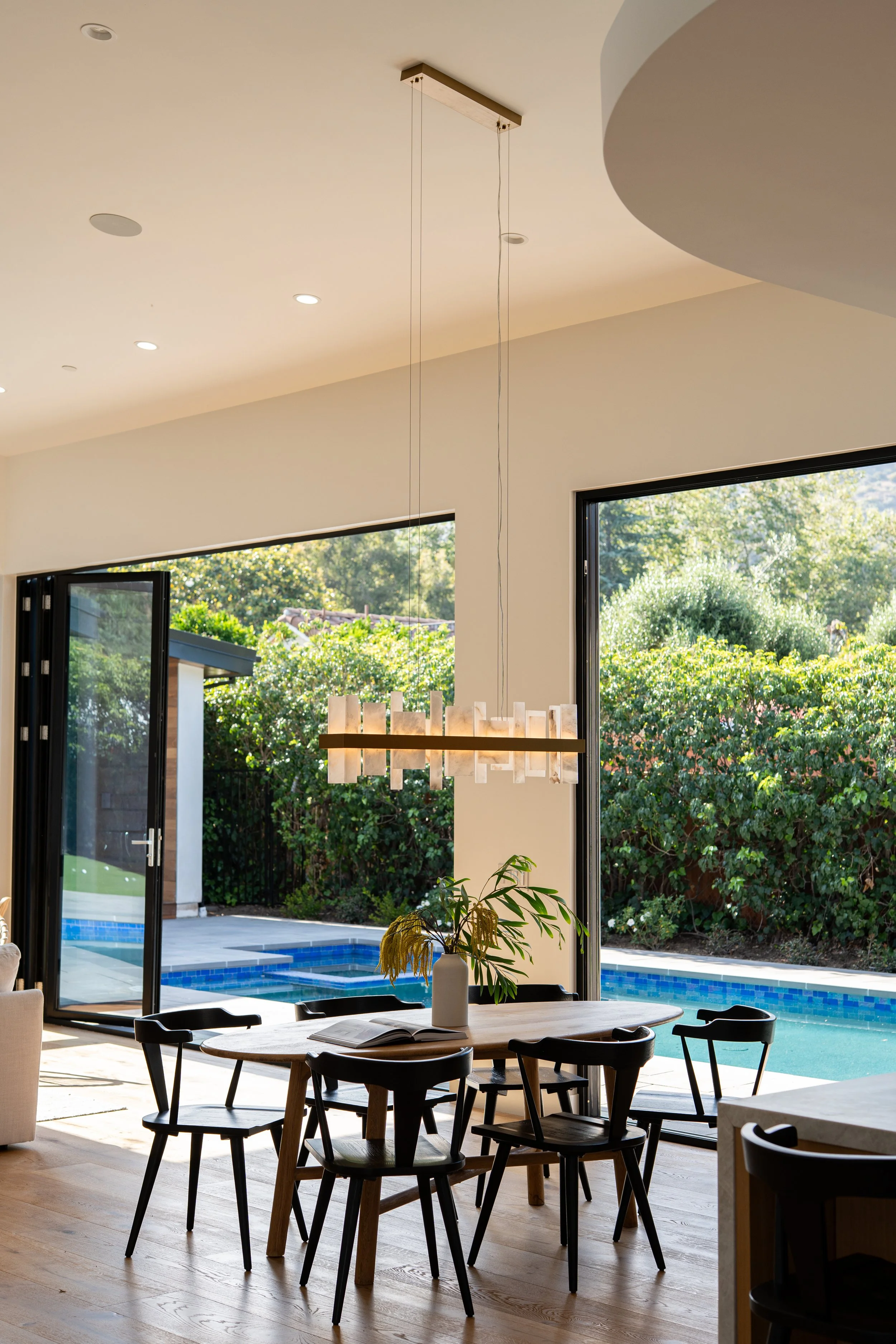 Dining area open concept with dining table and chairs with hanging alabaster chandelier