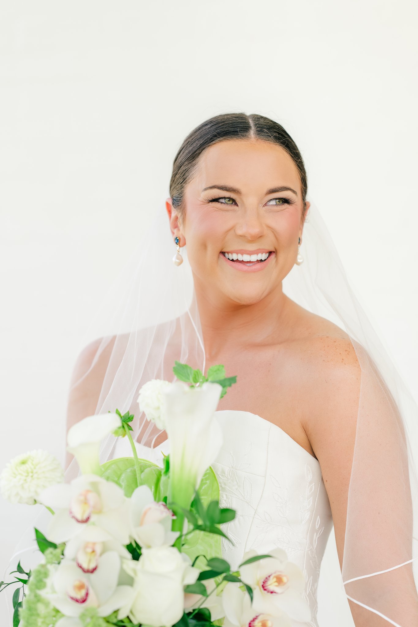 Wedding glam details featuring bridal hairstyle, veil, and elegant makeup artistry