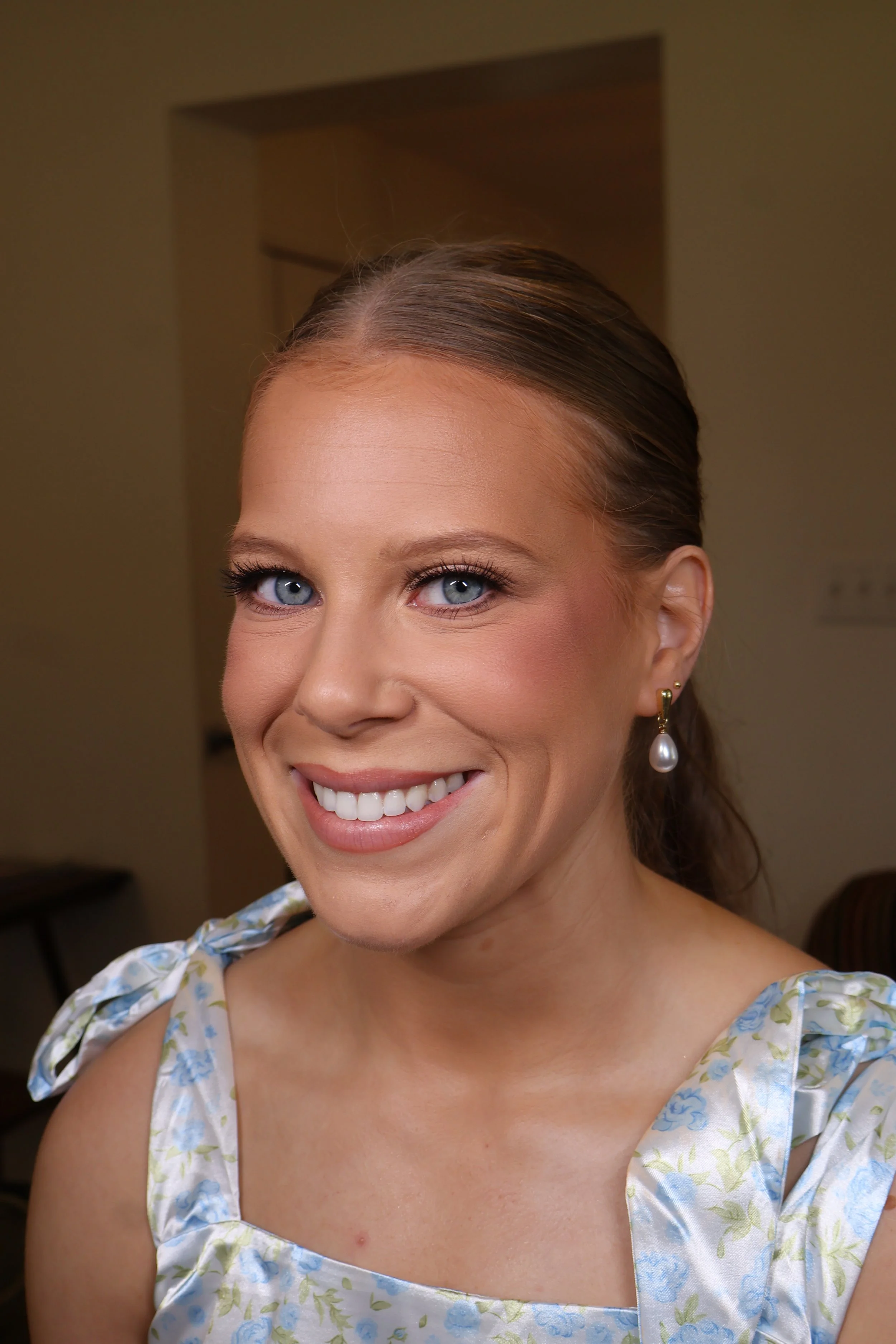 Sleek low bun bridal hairstyle with polished finish by mississippi wedding stylist