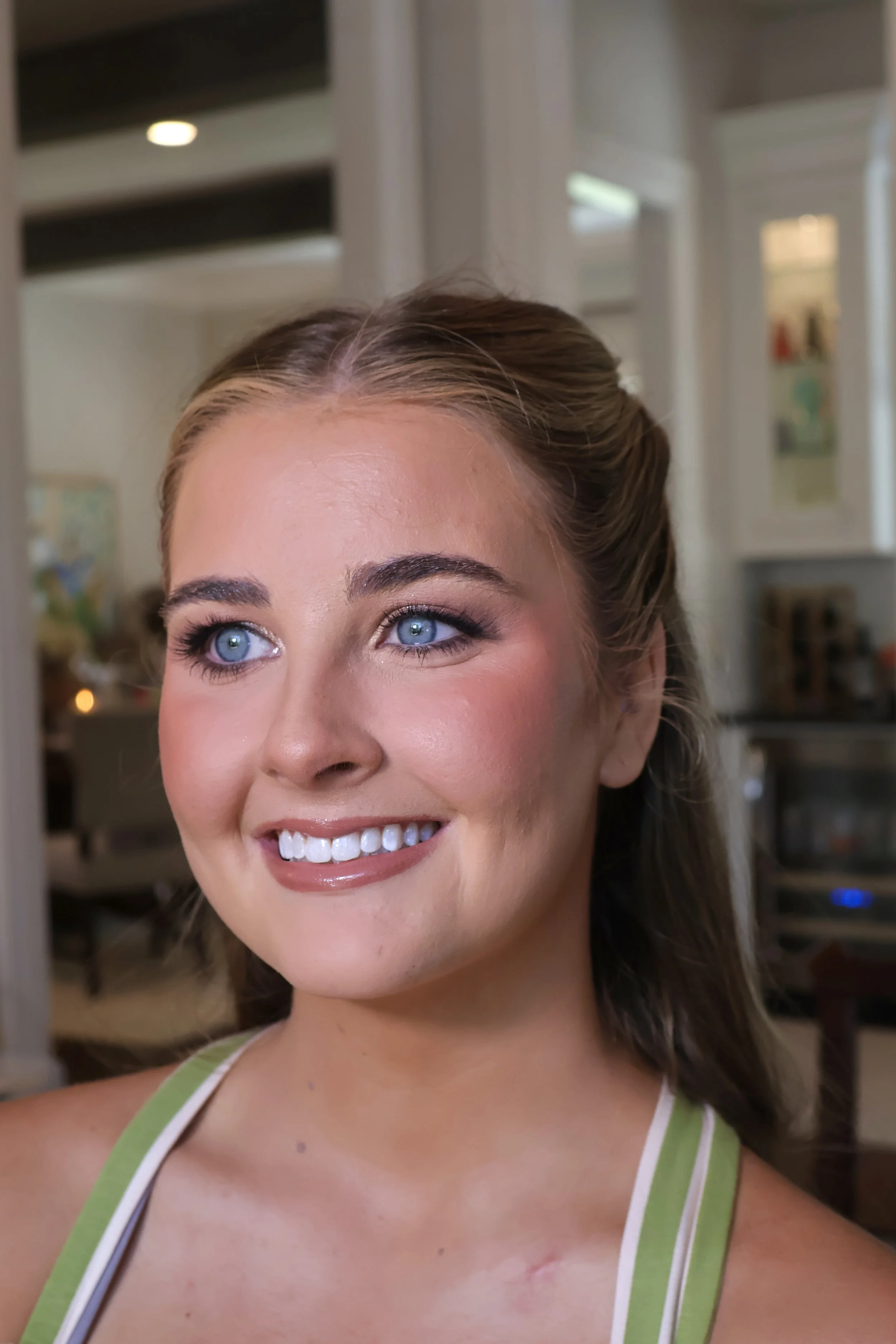 Bride with glowing airbrush makeup and textured low bun by Golden Girls Glam