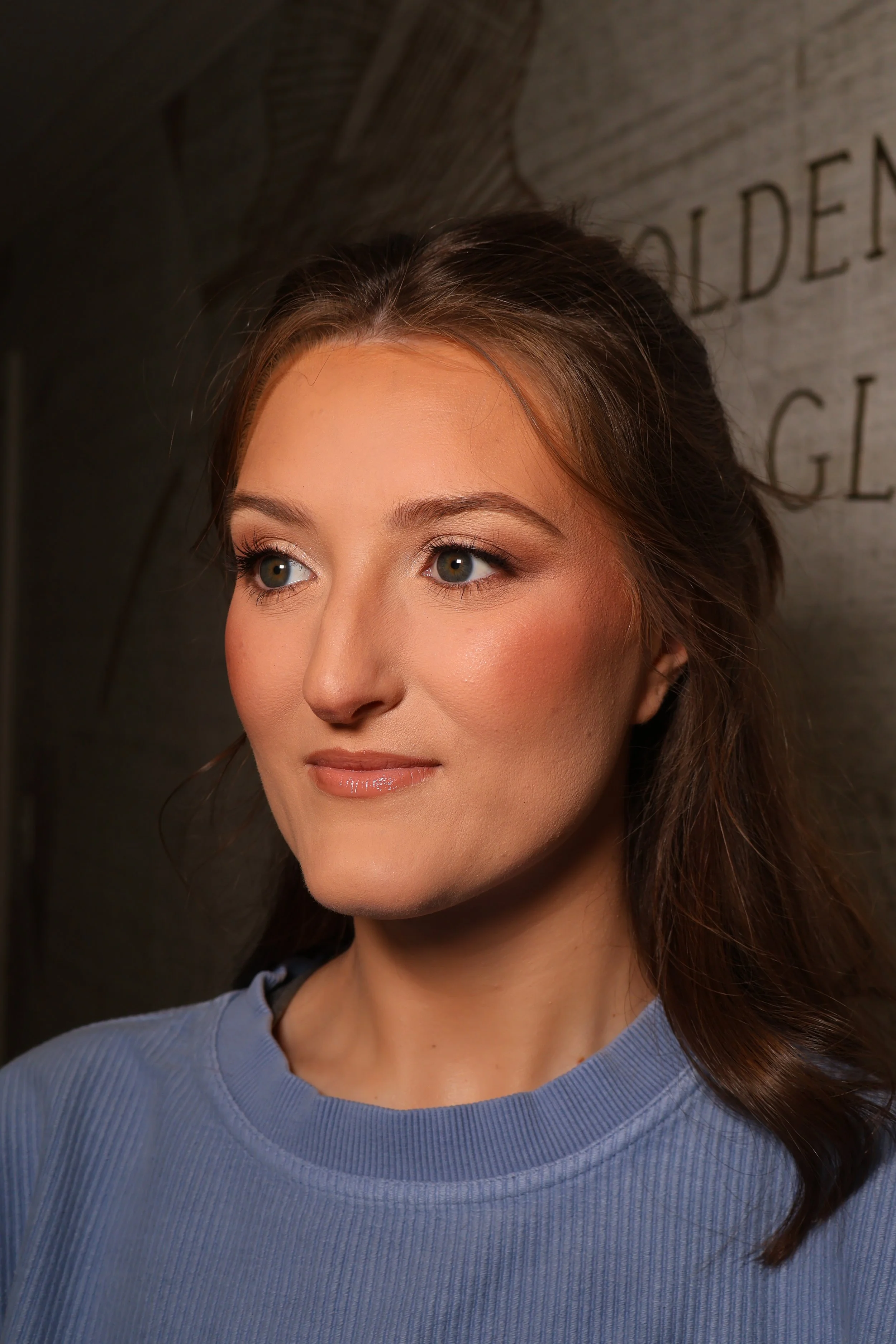 Bridal makeup detail with dewy finish, peach tones, and defined brows