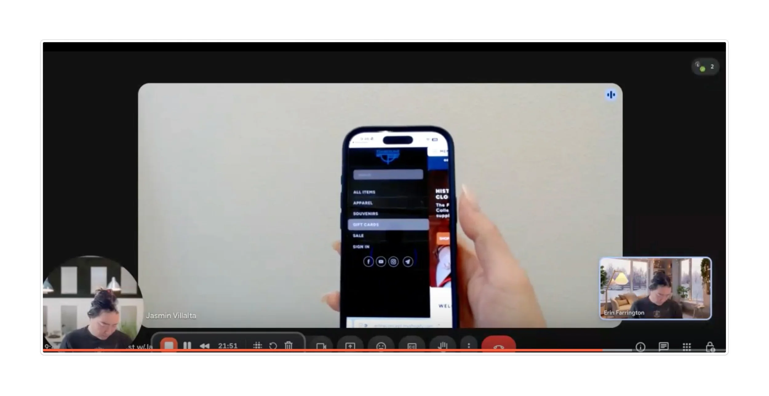 A person holding a smartphone displaying a shopping app, with two small video call windows of women in the bottom left and lower right corners.