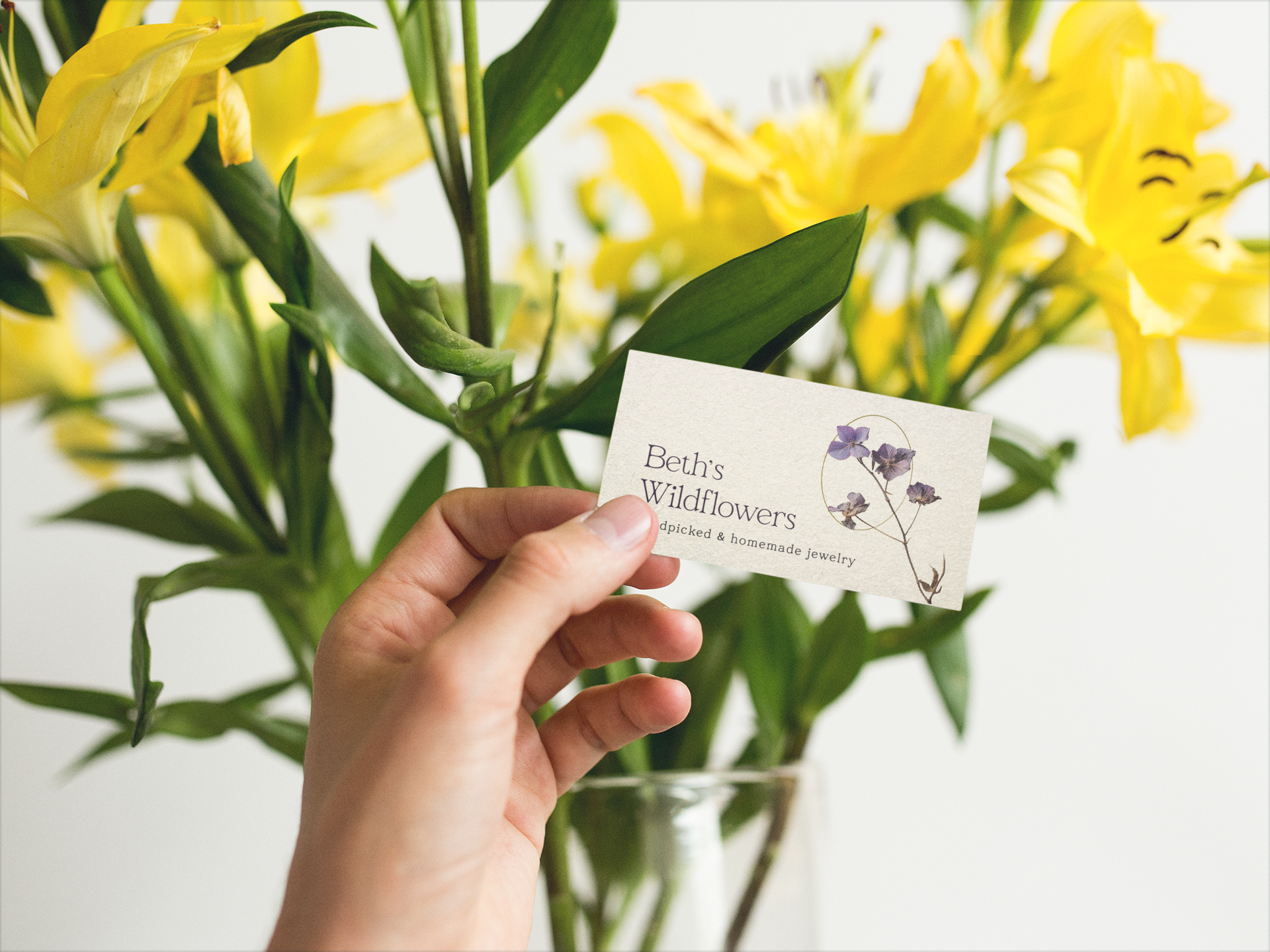 business-card-mockup-held-next-to-yellow-flowers-a15006.png