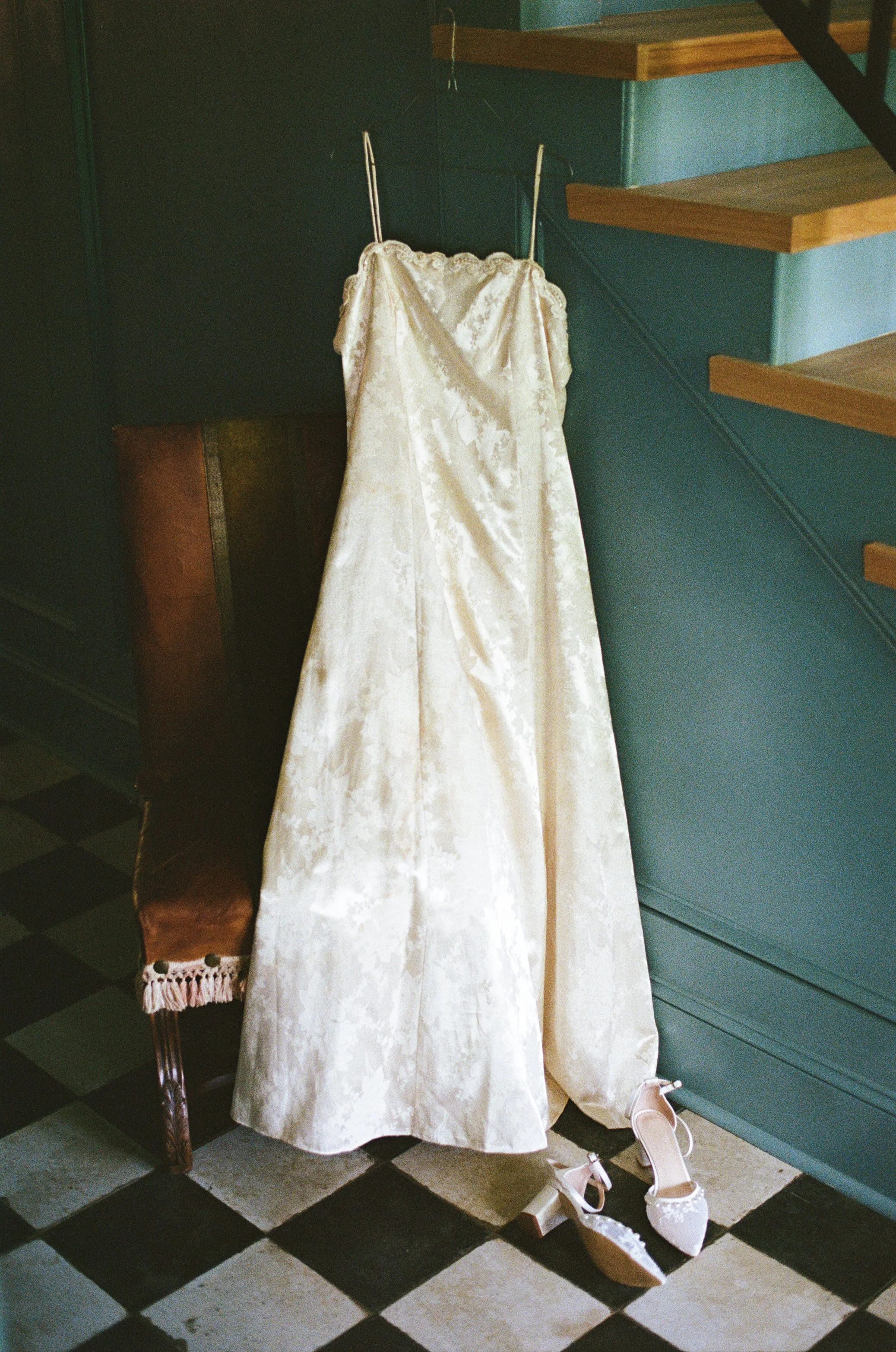 Editorial wedding photograph of a wedding dress hanging on a stairwell from a Southern California wedding