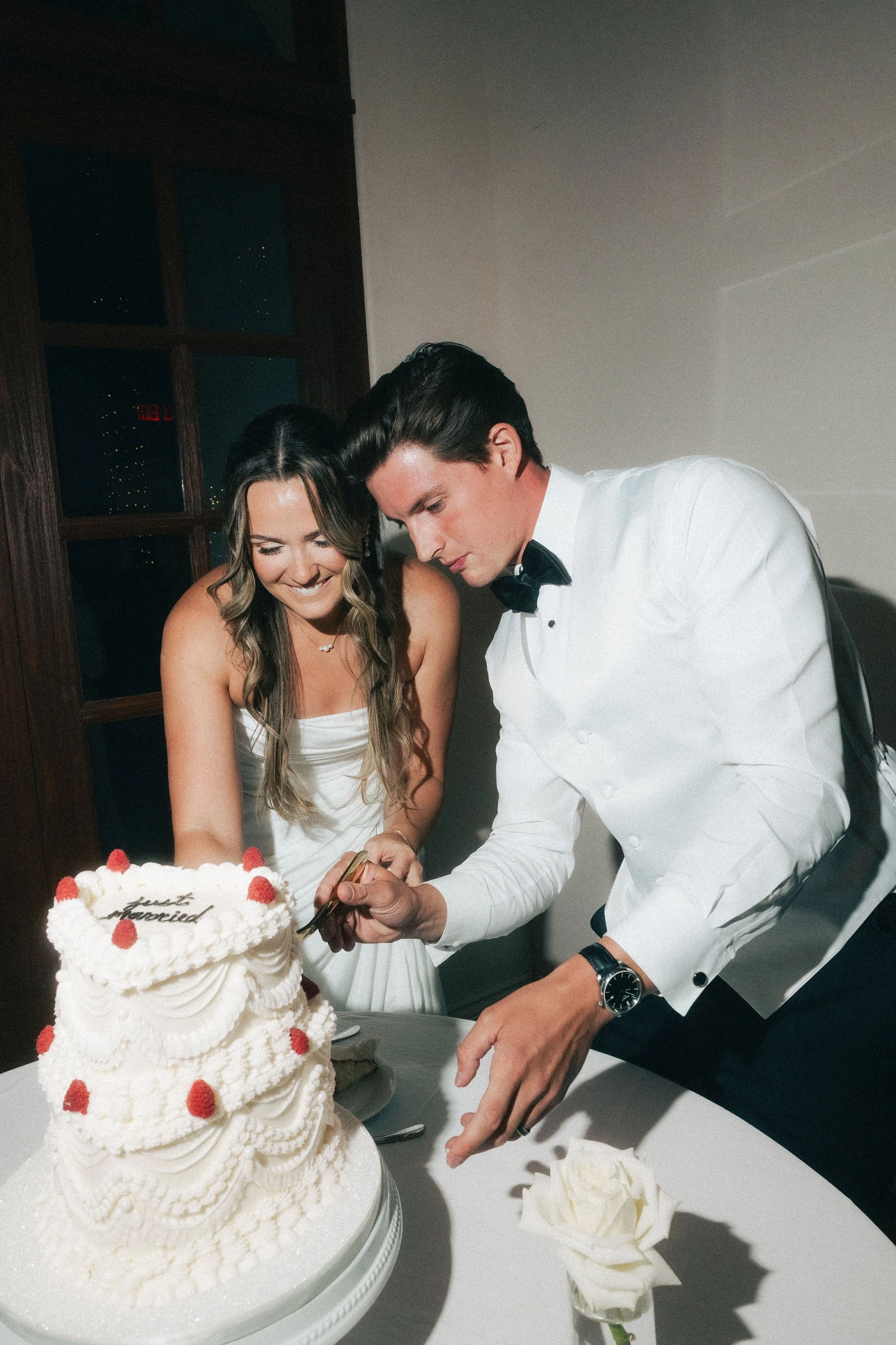 Editorial wedding photograph of a couple cutting their wedding cake at a southern California wedding