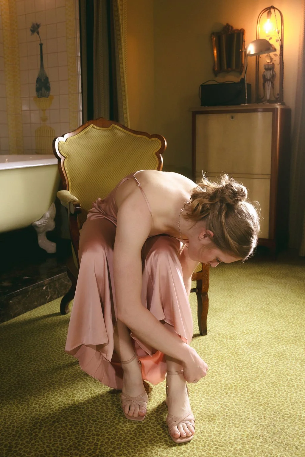 Documentary wedding photograph from a California wedding of a bridesmaid putting on her shoes