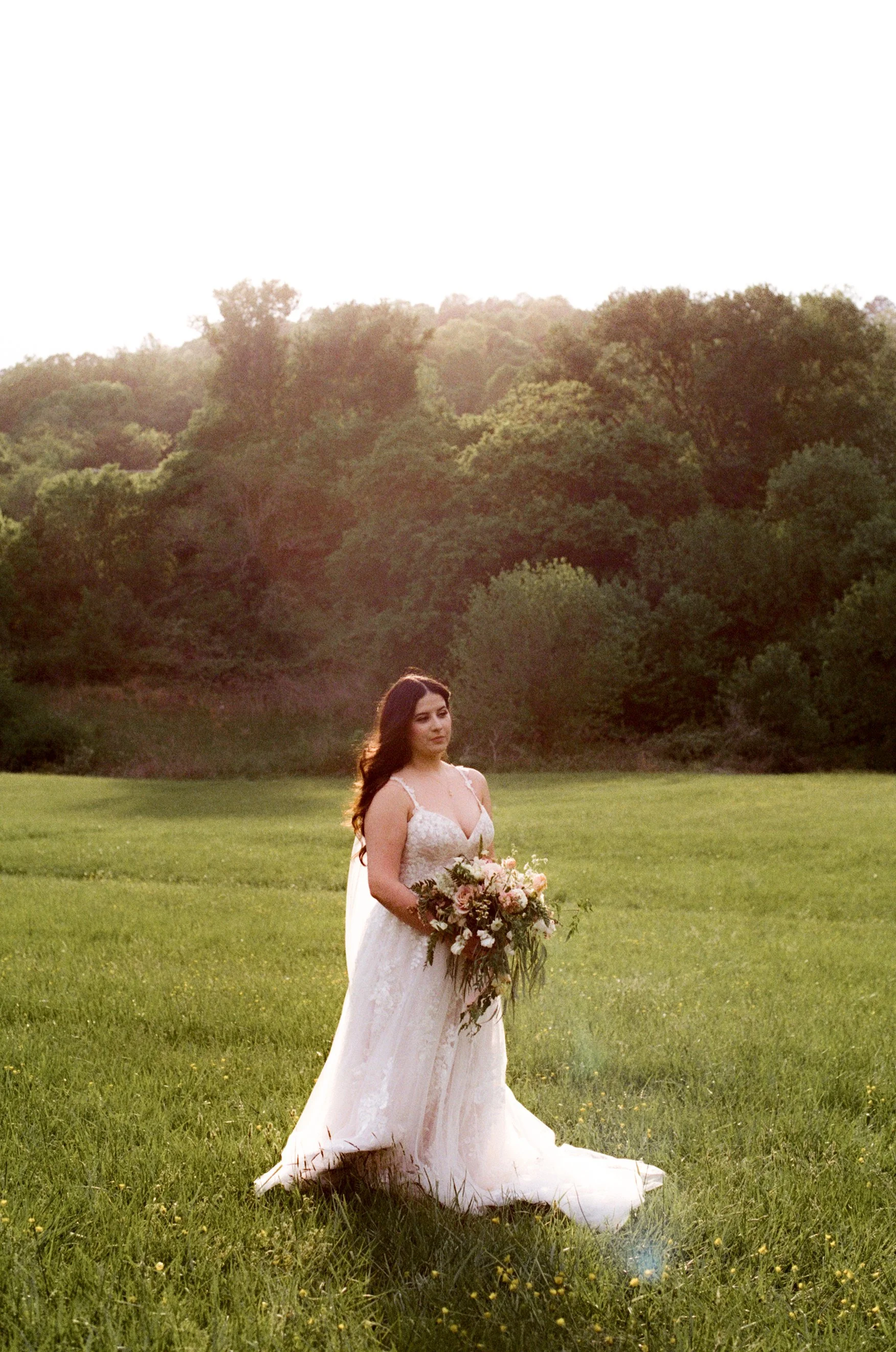 Wedding photograph of a bride standing in a field holding a bouquet in southern California 