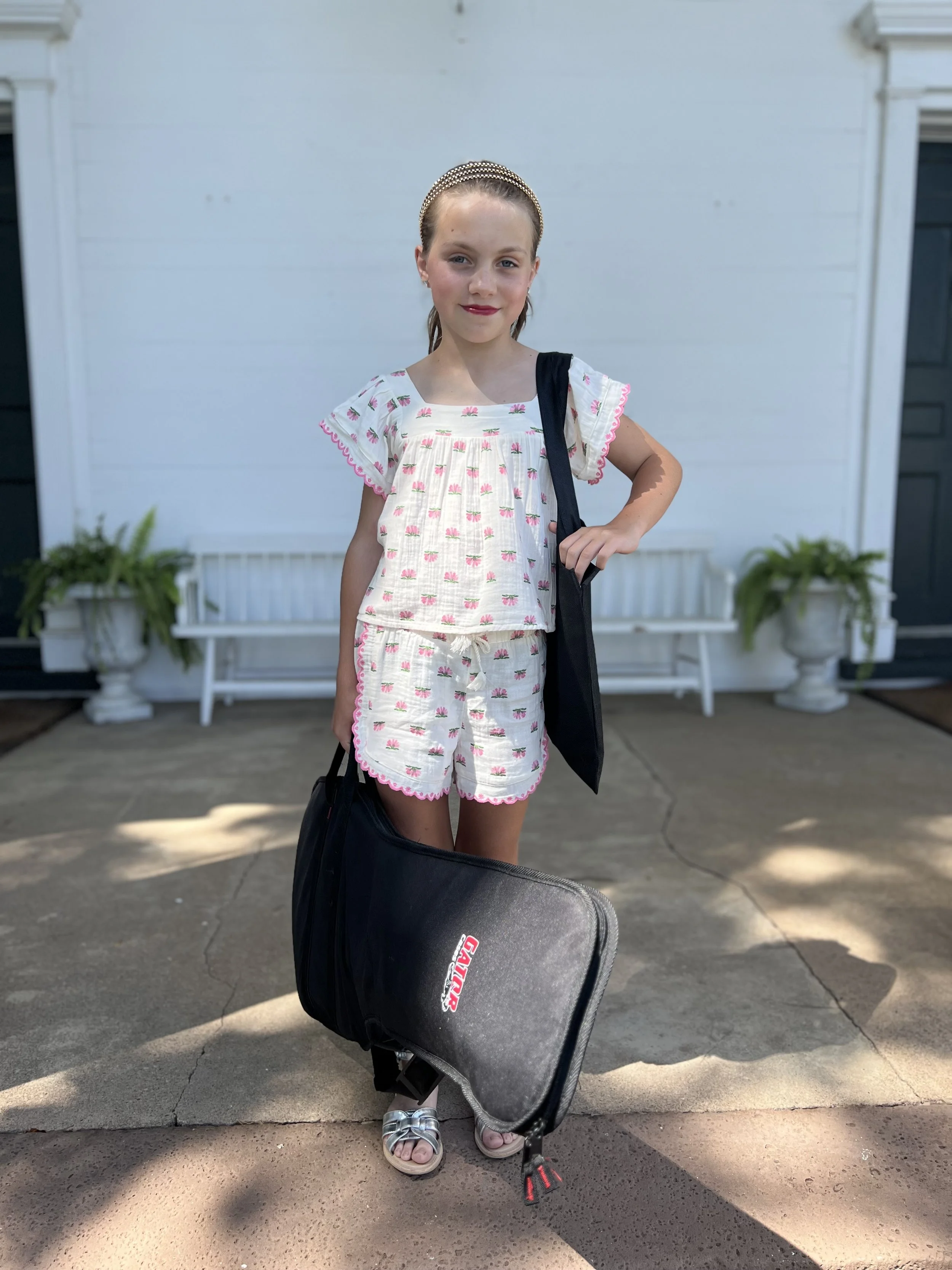 A girl carrying an electric guitar outside after her performance at Lifelong Music School's 2024 annual recital.
