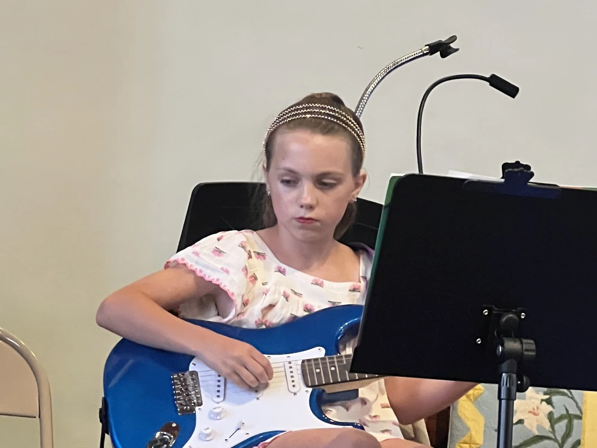 A girl playing an electric guitar at Lifelong Music School's 2024 annual recital.