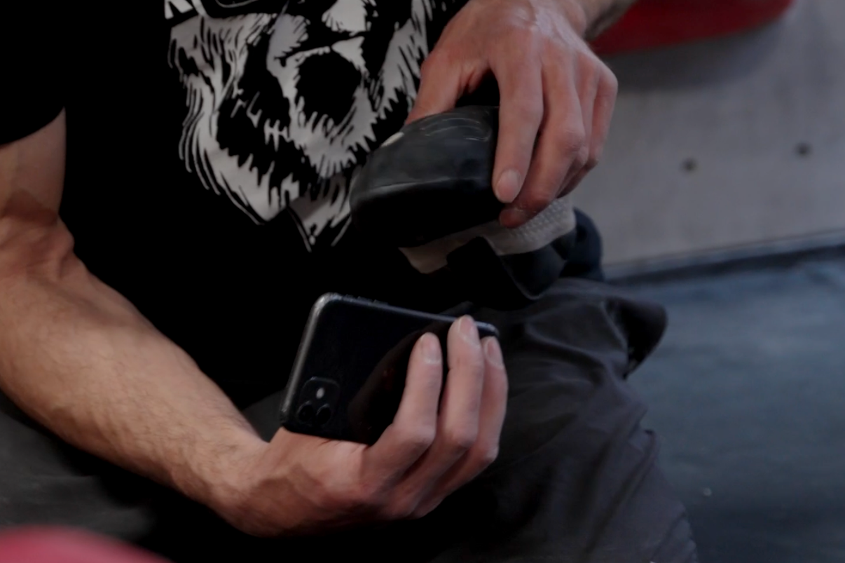 Person holding a smartphone and a hockey puck.