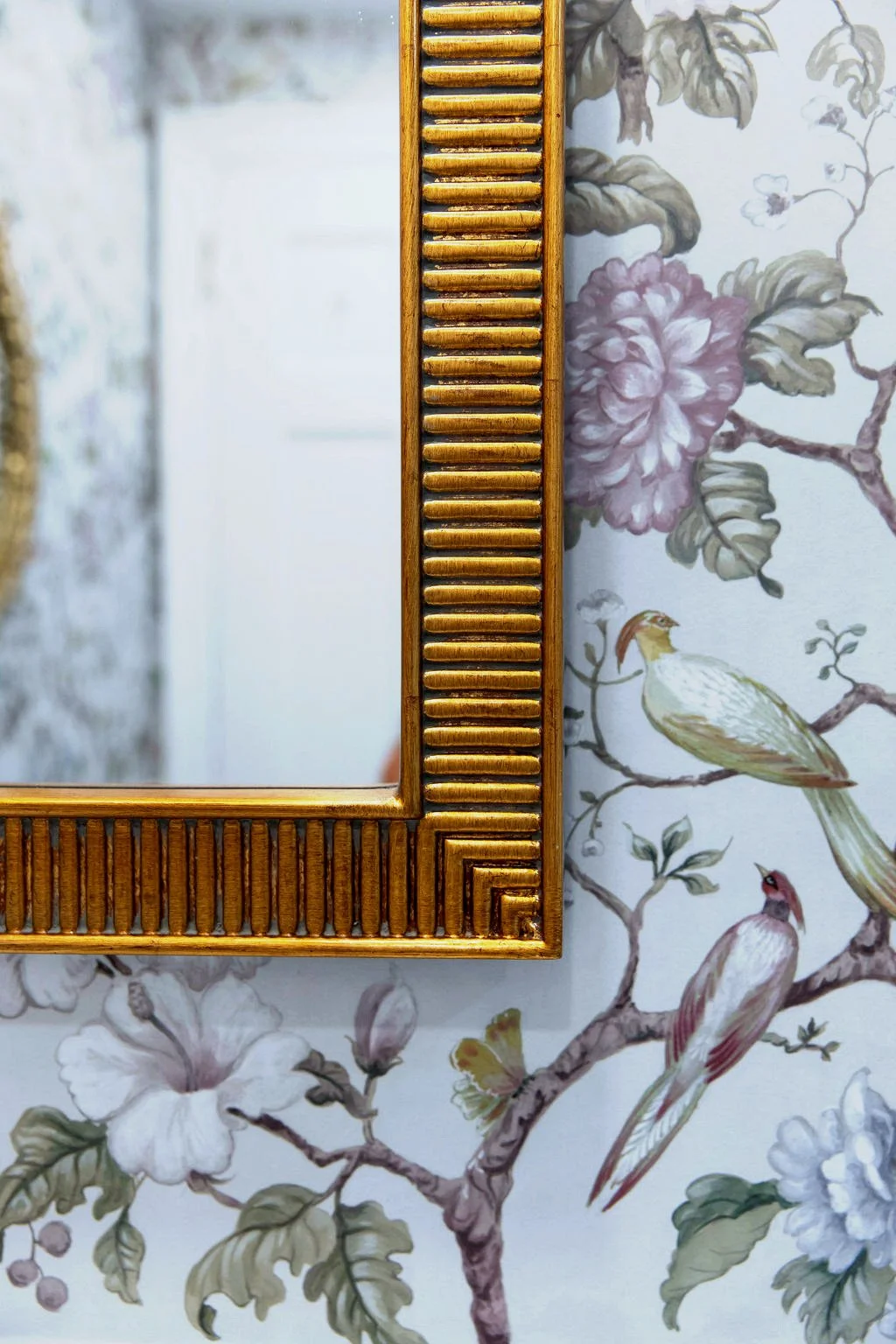 Detail of ornate gold mirror against botanical floral wallpaper in primary bathroom designed by Caroline by Design.