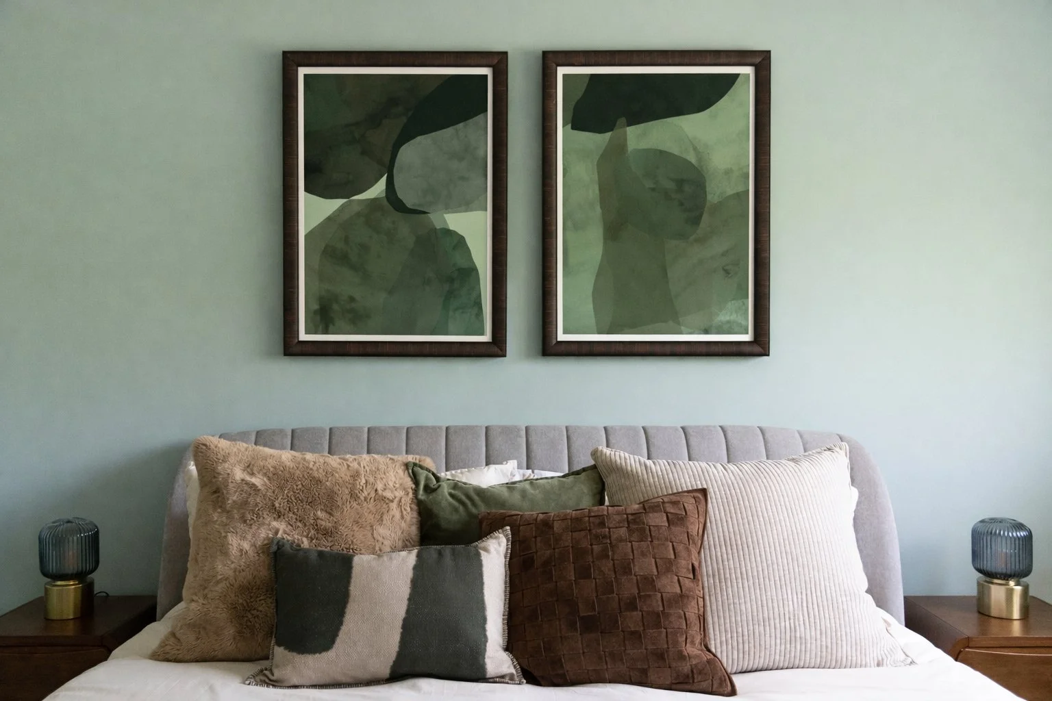 Abstract botanical artwork above upholstered bed in an organic coastal bedroom designed by Caroline by Design in Montclair, NJ.