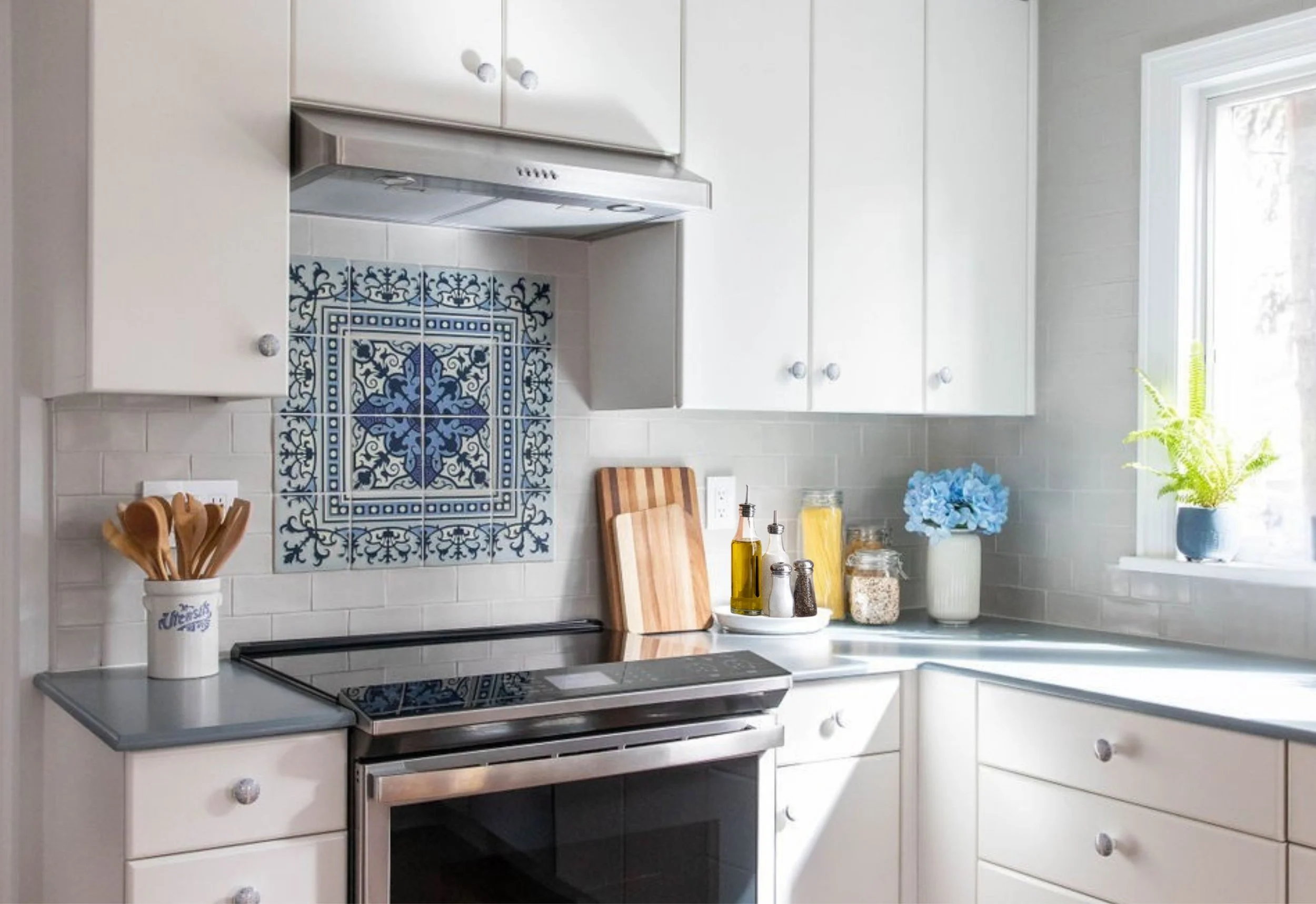 Bright white kitchen featuring a blue patterned tile backsplash and classic cabinetry.