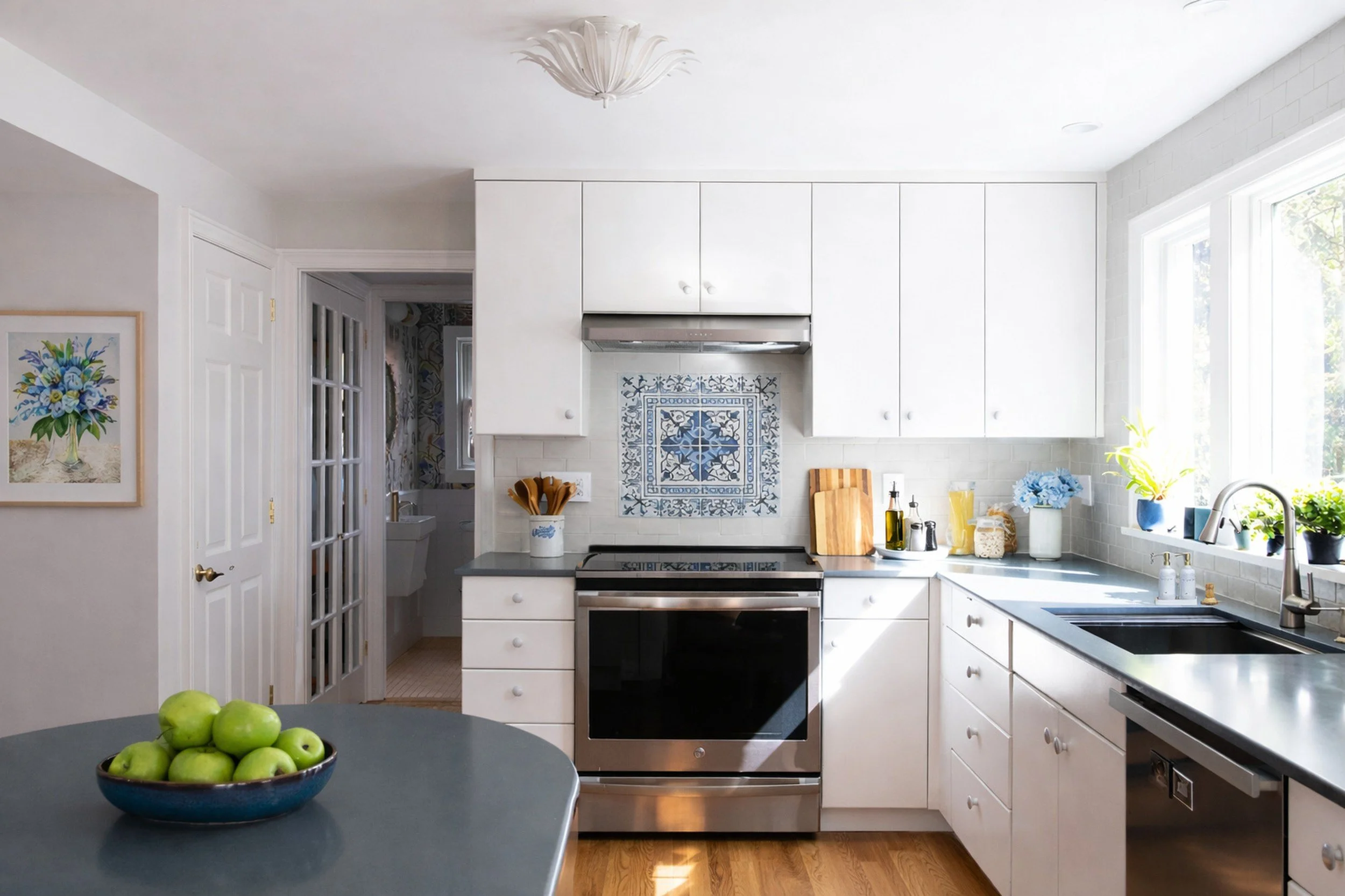 Classic white kitchen featuring a blue patterned tile backsplash and clean, modern finishes.