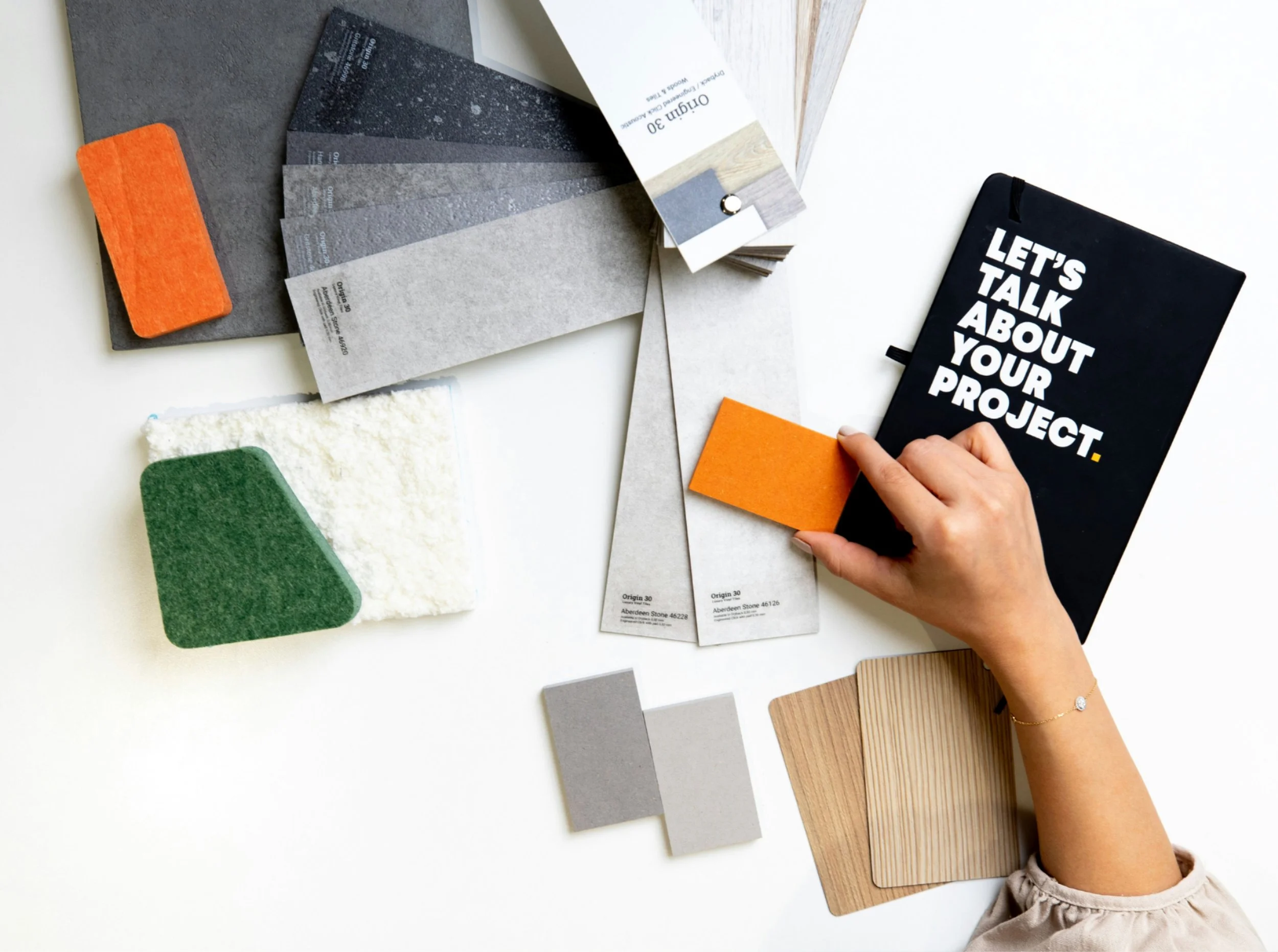 Interior design material samples including paint swatches, fabric, wood finishes, and wallpaper selections by Caroline by Design.