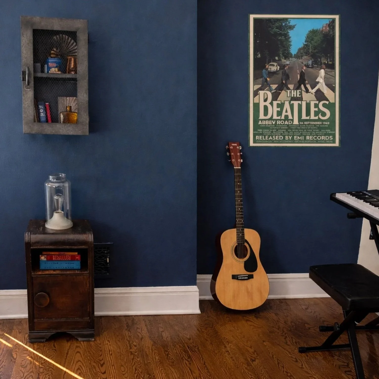 Music corner in an industrial teen bedroom featuring acoustic guitar, keyboard, and Abbey Road artwork against a navy accent wall — interior design by Caroline by Design in Montclair, NJ.