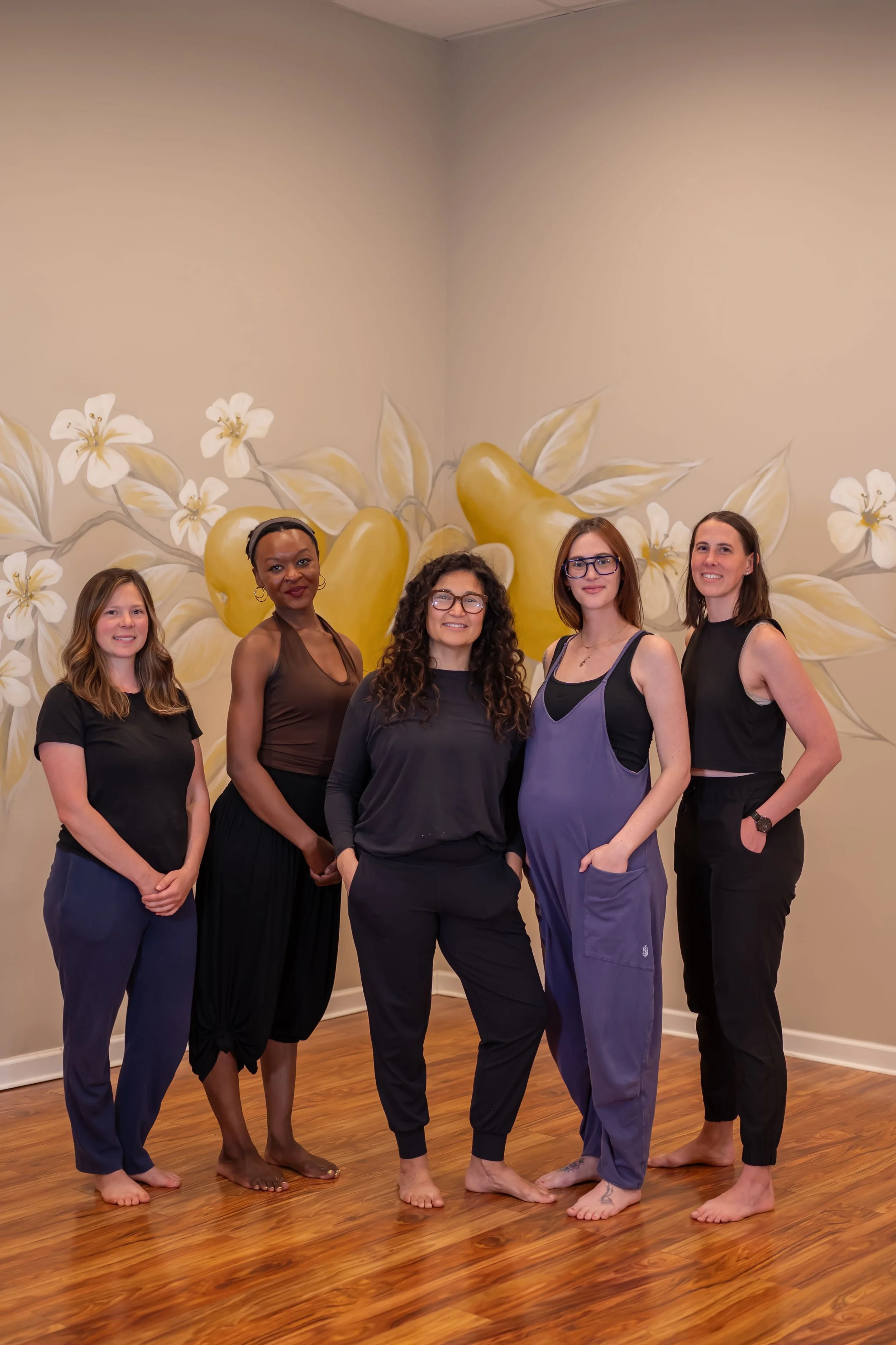 Group of female yoga instructors standing in pear studio