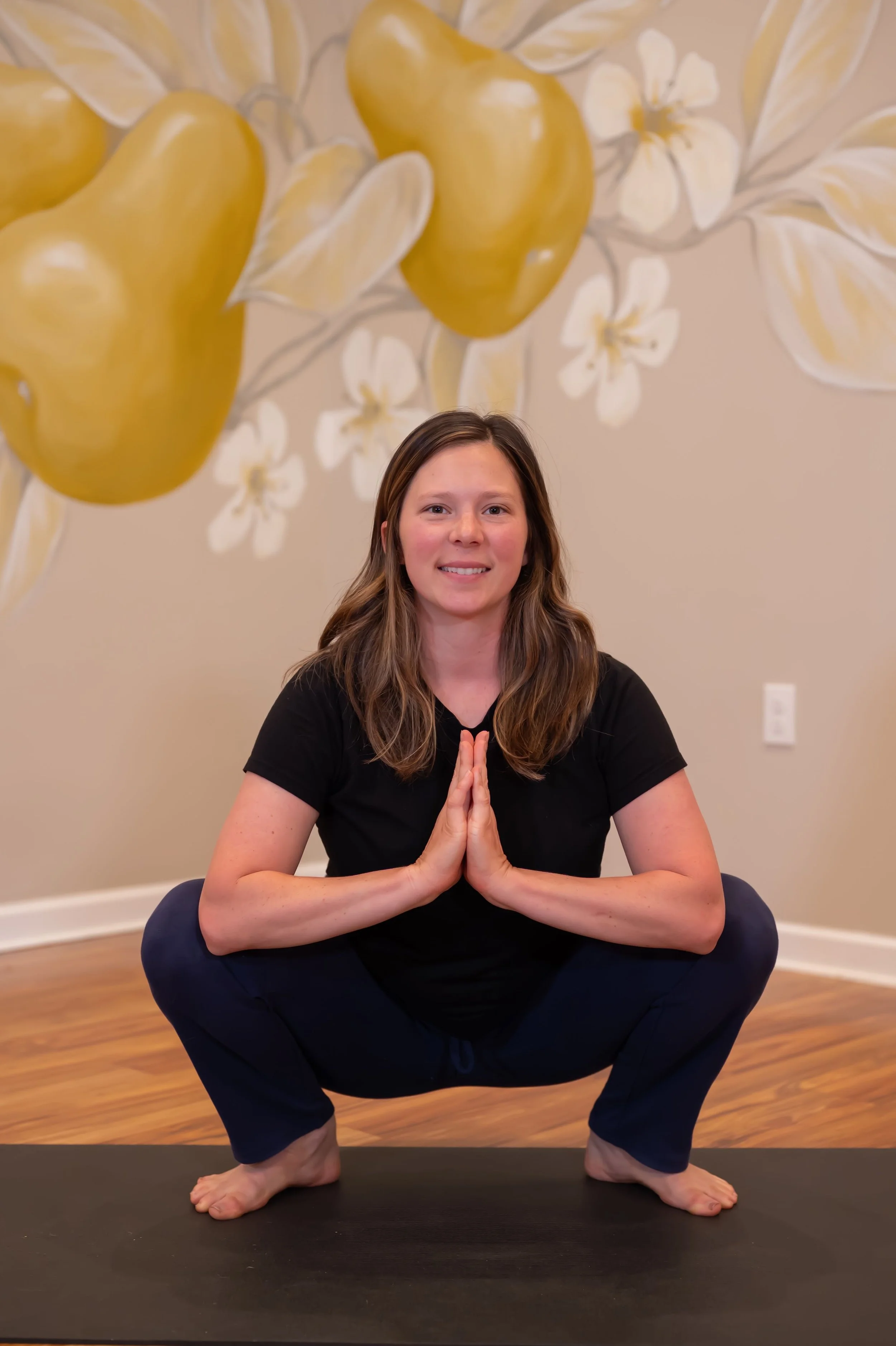 Pear yoga instructor squatting in pose