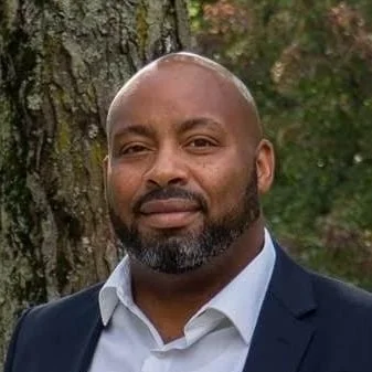 headshot of a man in a suit looking at the camera