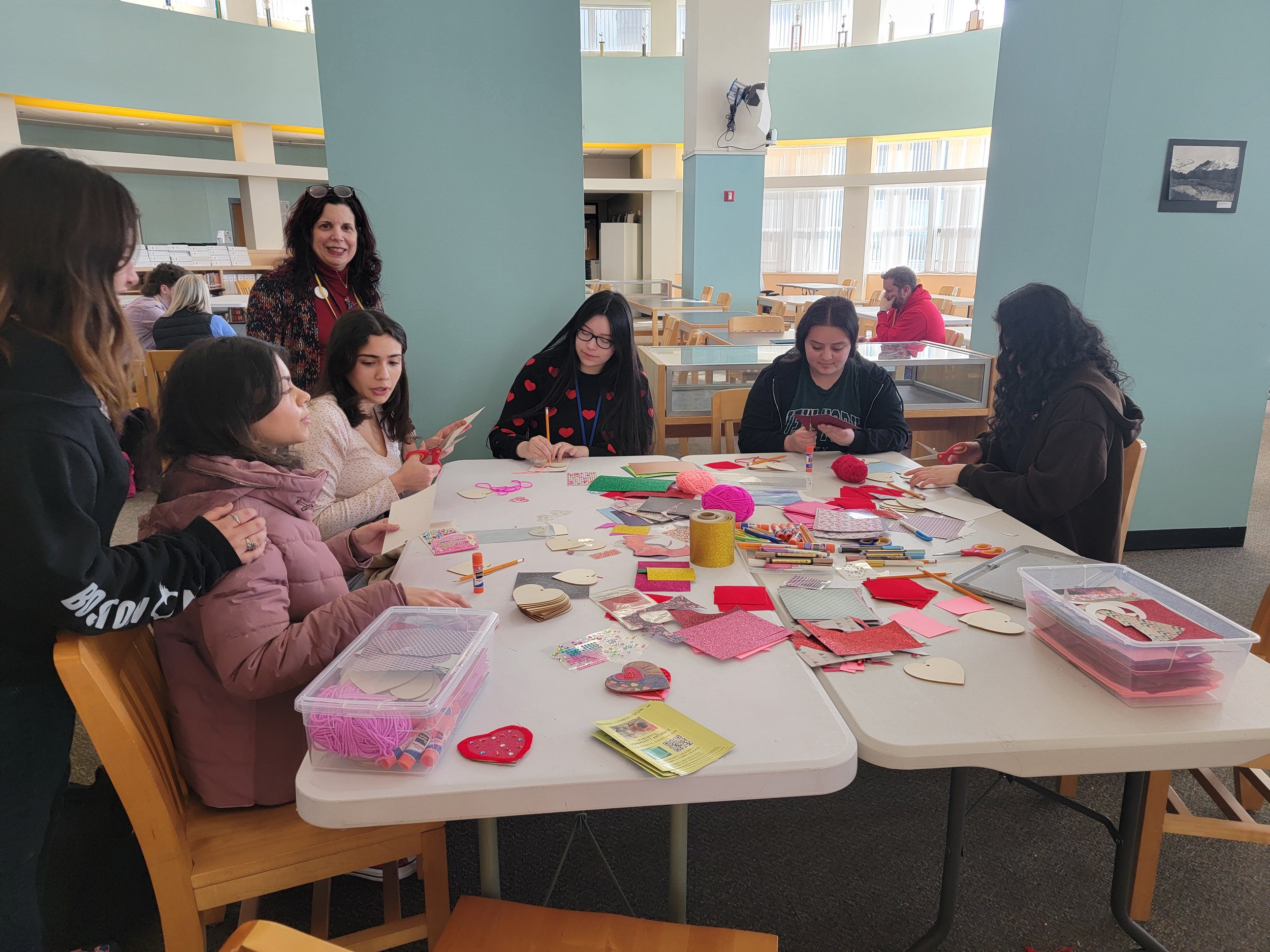 Teens and adults creating artwork at an A.L.E. event hosting in a public space