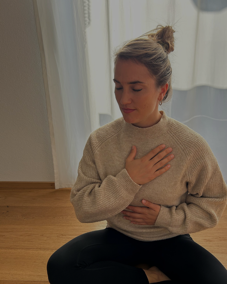 Drei lachende Frauen im Sonnenlicht, eine hält einen weißen Regenschirm und trägt einen Hut, die anderen tragen Brillen und einen warmen Pullover oder Mantel.