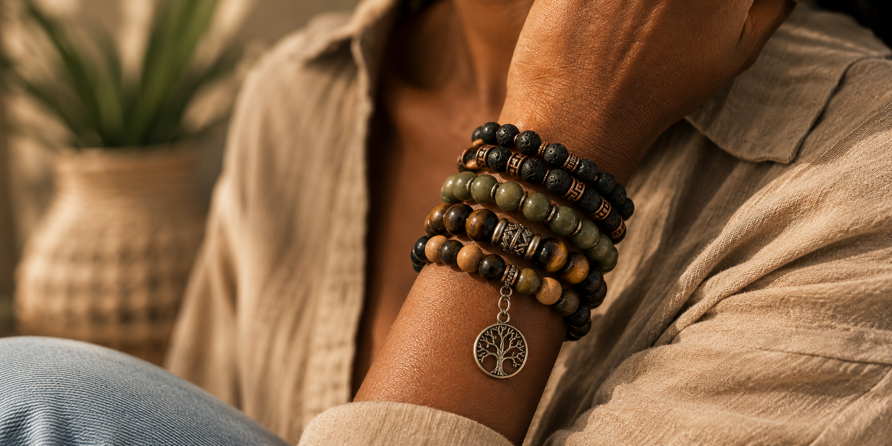 Stack of handmade gemstone and beaded bracelets featuring a silver Tree of Life charm.