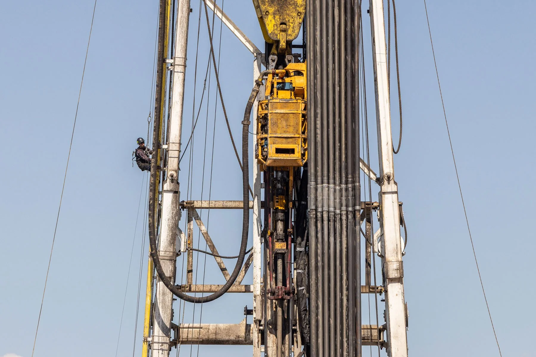 Oil and gas industry worker climbing a derrick on an oil and gas drilling rig in Central Wyoming.