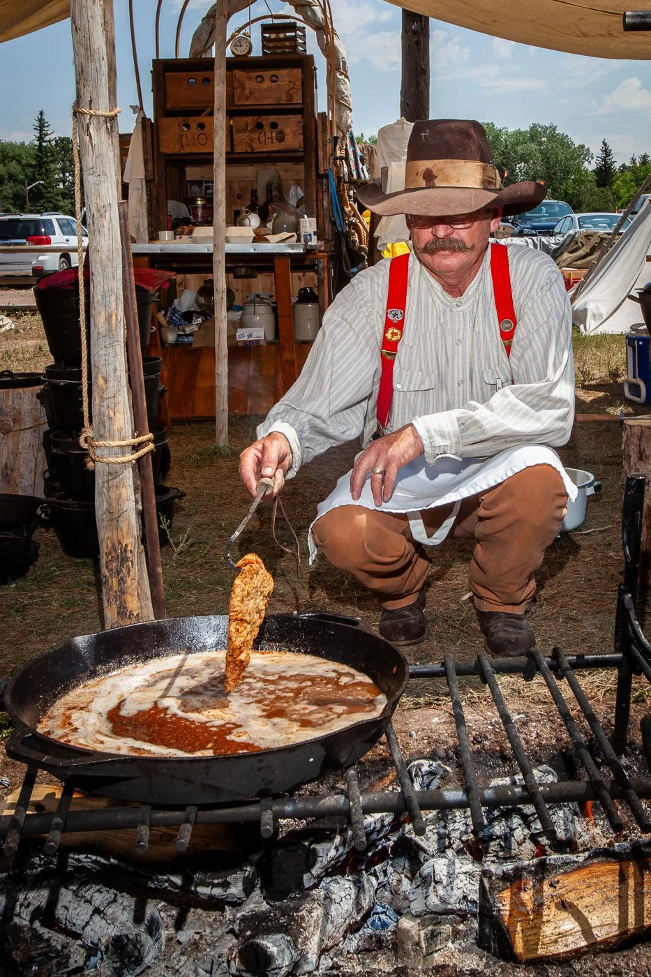 A cowboy cooks chicken-fried steak during the Chuck Wagon Cook-Off at Cheyenne Frontier Days in Cheyenne, Wyoming.