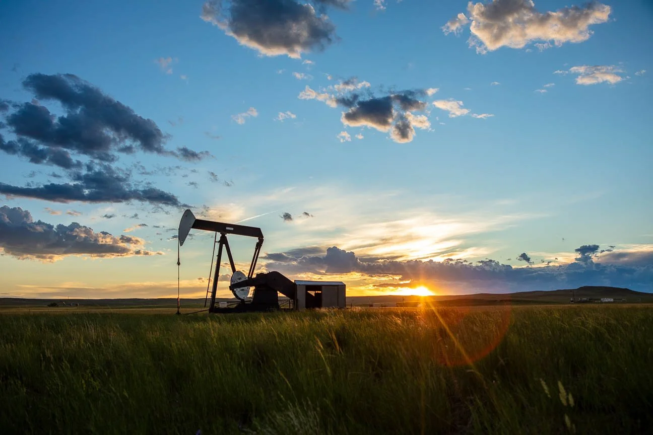 Sun setting over a pump jack in Central Wyoming.